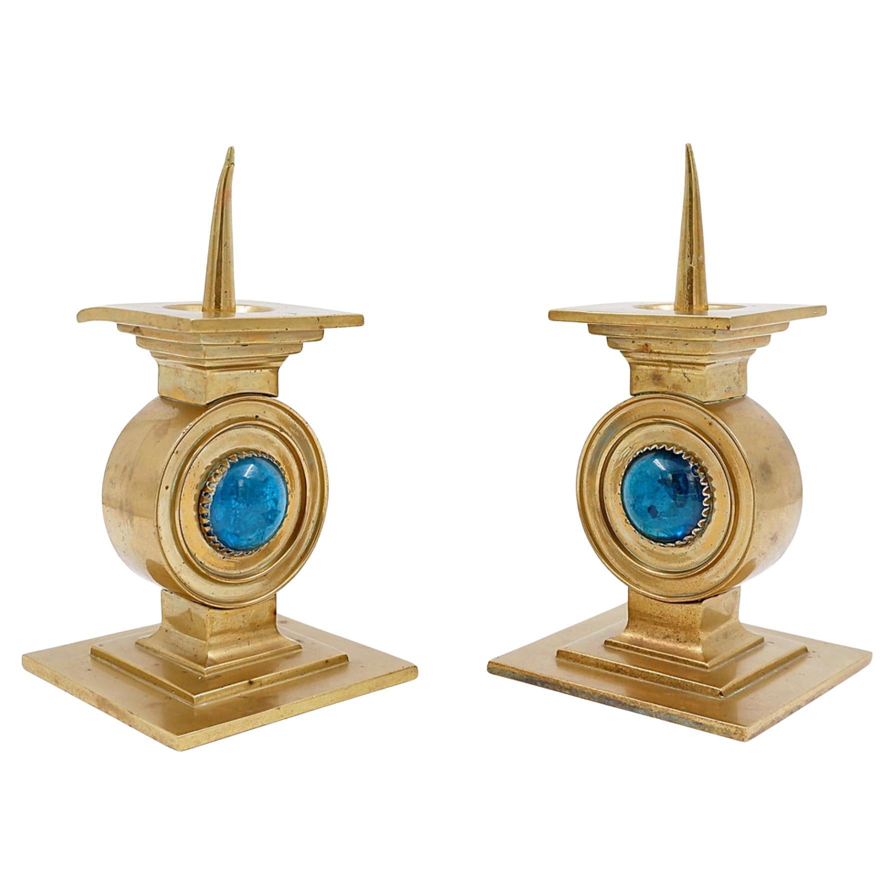 Coppia di candelabri in ottone decorati con una pietra blu intarsiata al centro in vendita