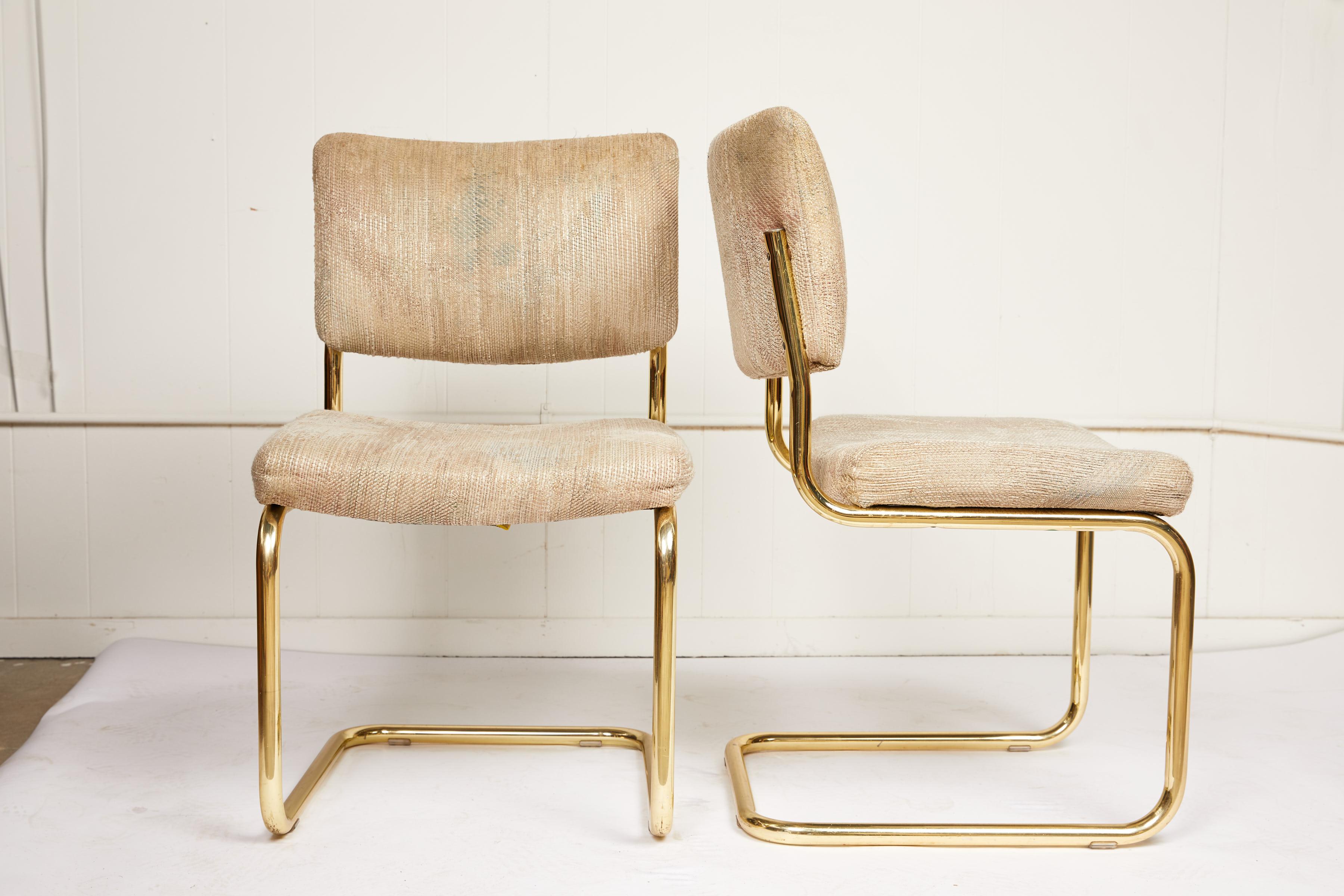 20th century pair of cantilever chairs made of tubular brass frames and manufactured by Chromcraft. The chair seats and backs feature the original upholstery. The cushions are in good condition but the fabric should be replaced.