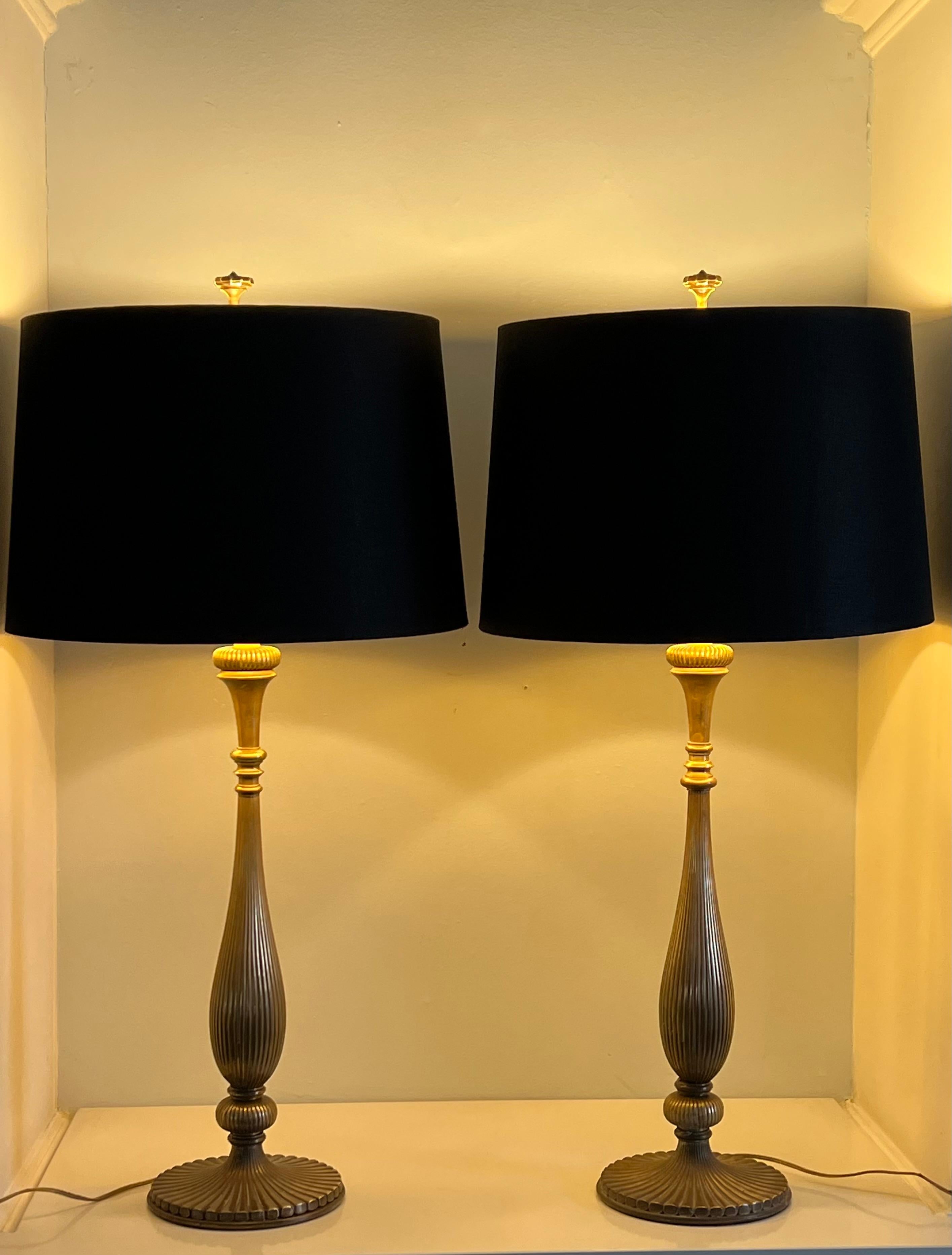 A wonderful pair of brass Chapman lamps. Iconic mid century lamps with a ribbed brass candlestick style body. Quite impressive and sturdy. The shades have a gold foil lining which makes for a very nice ambient glow. One center socket per lamp.
