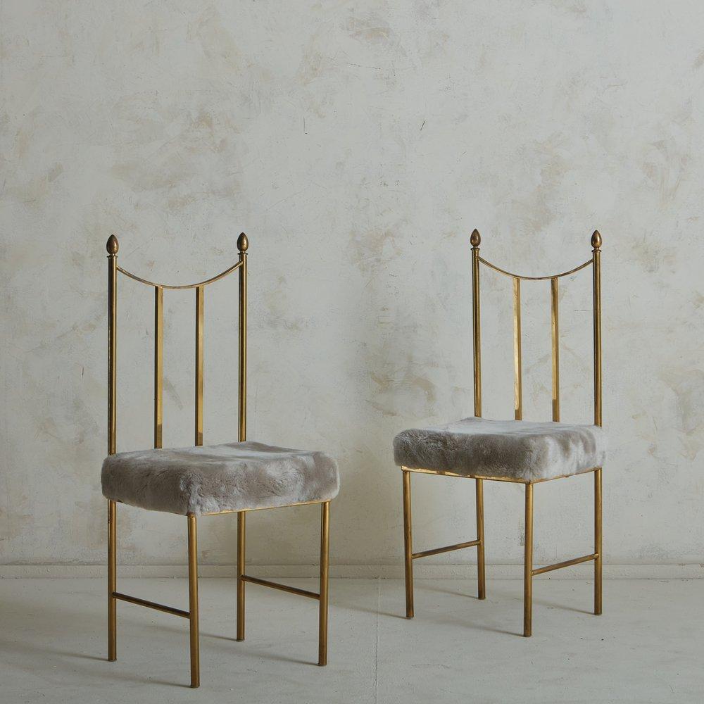A pair of 1970s Italian Chiavari chairs featuring sleek patinated brass frames with ladder backs and finial details. These chairs were freshly reupholstered in a luxe gray shearling. Sourced in Italy, 1970s.