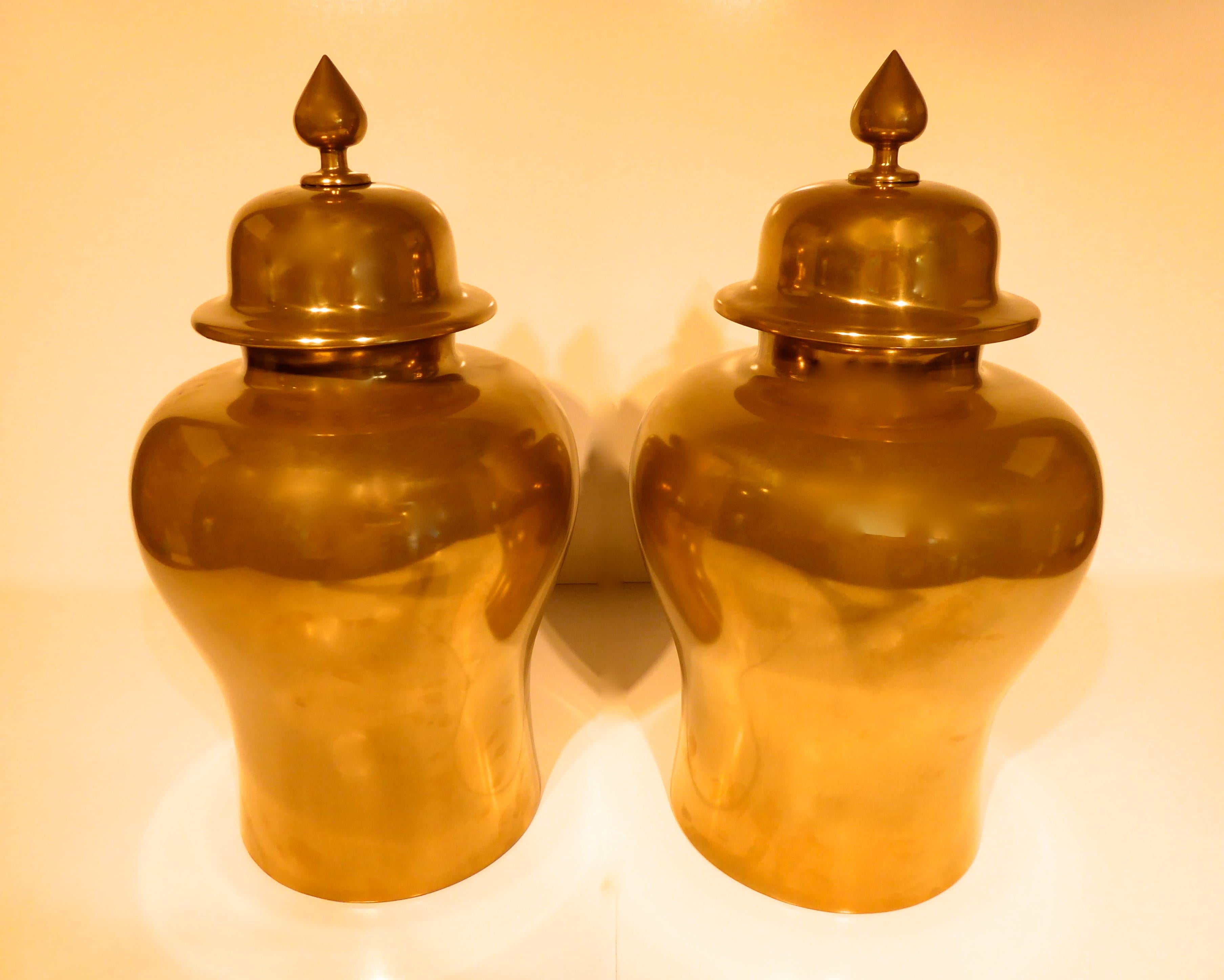 A glamorous pair of brass coated hardwood temple jars, circa 1980s. They jars have a tag on the bottom 