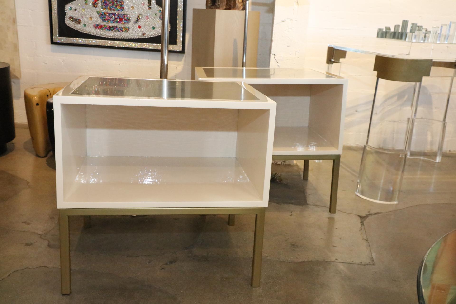 A pretty pair of lacquered and brass coated metal and wood end or side tables. In a nice ivory color with brushed brass finish on top. Recently redone, they are in good condition, with minor handling marks.