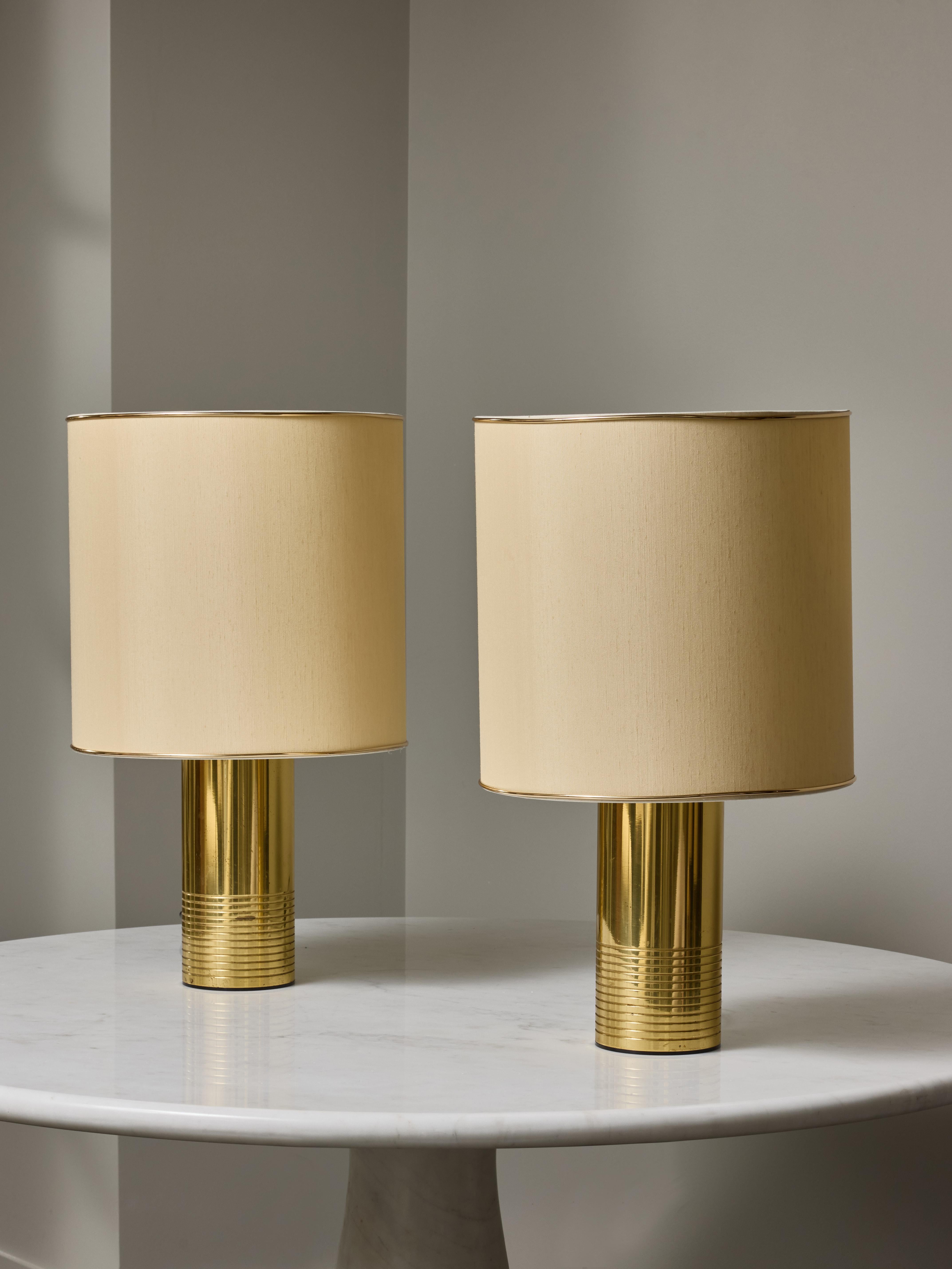 Paire de lampes de table cylindriques en laiton avec décors de stries sur la moitié inférieure et trois sources de lumière par lampe avec interrupteur divisé.

Ombres nouvellement fabriquées