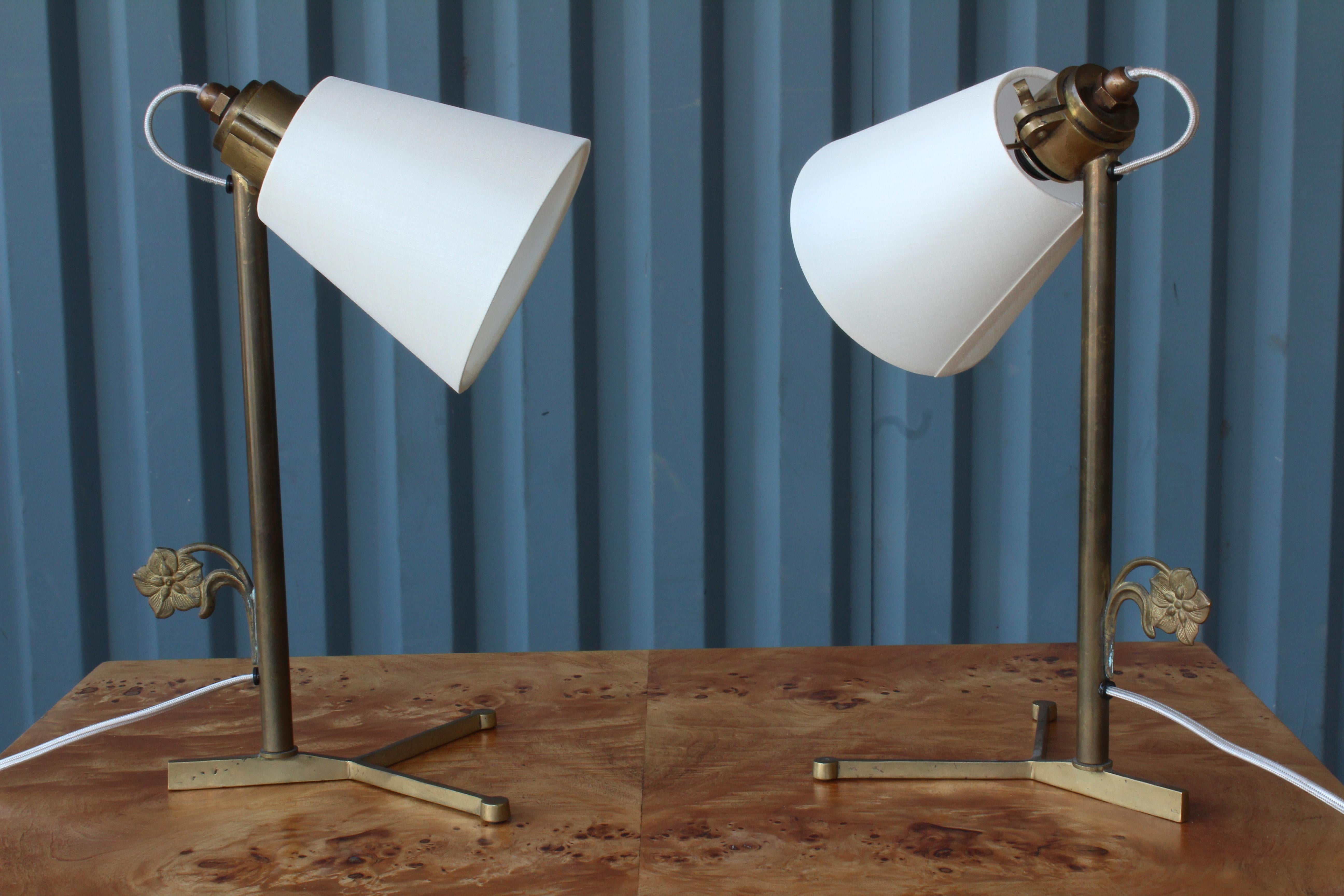 Pair of brass desk lamps with a flower detail. They are sold as a pair and have been recently rewired. They have new custom made silk shades.
      