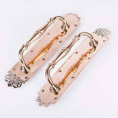 Pair of brass door pulls with the initials KSB to the top