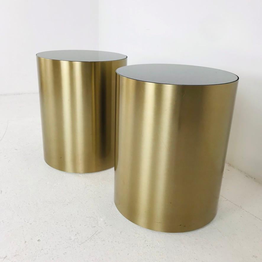 Paire de belles tables tambour en laiton poli avec des plateaux en marbre noir.