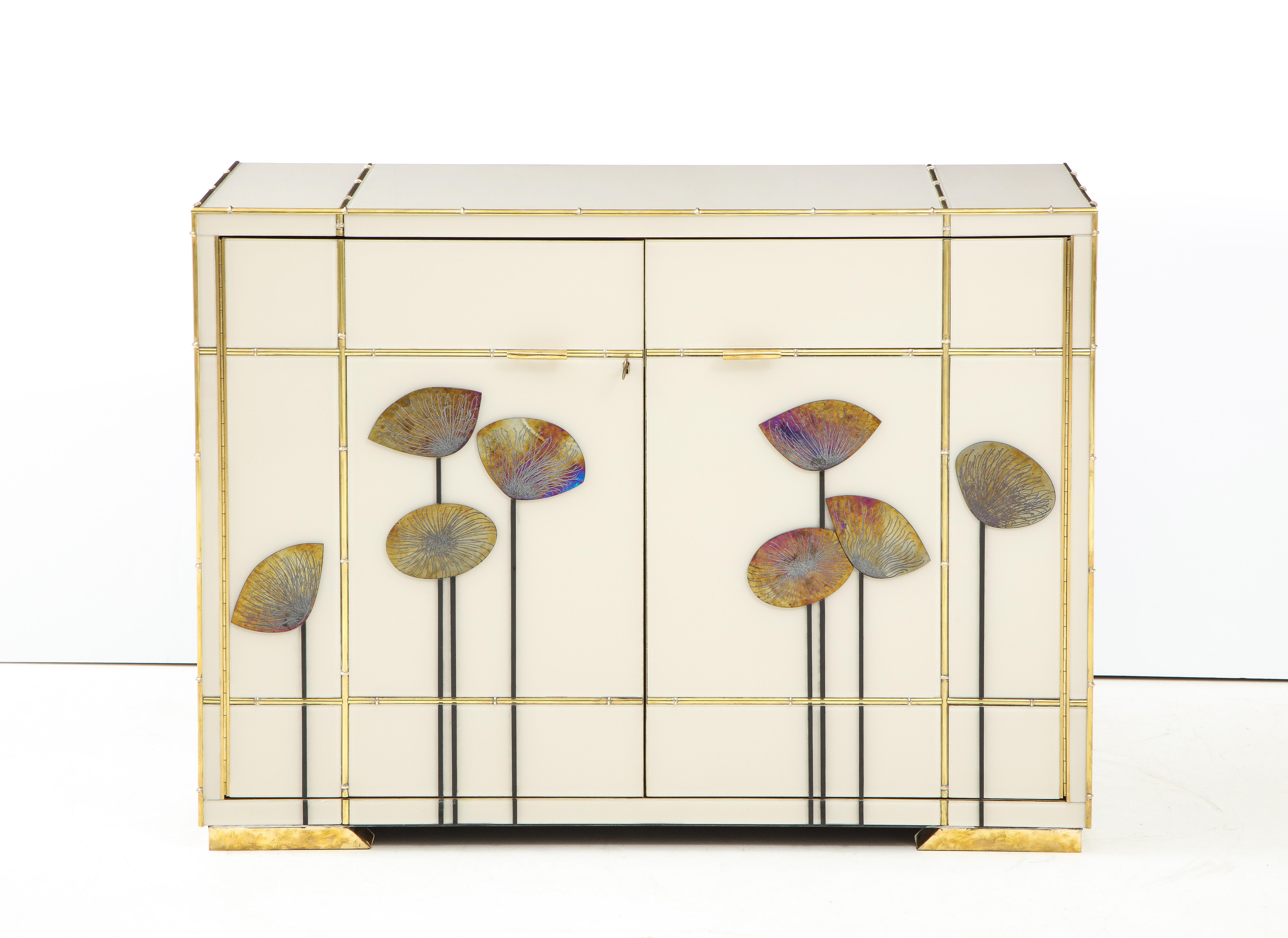 One of a kind pair of sideboards handmade in Venice, Italy by a master artisan and artist. Wooden frame is covered in ivory hand tinted Murano glass panels with faux bamboo brass inlays. Handcut iridescent gold glass Dandelions in a Classic