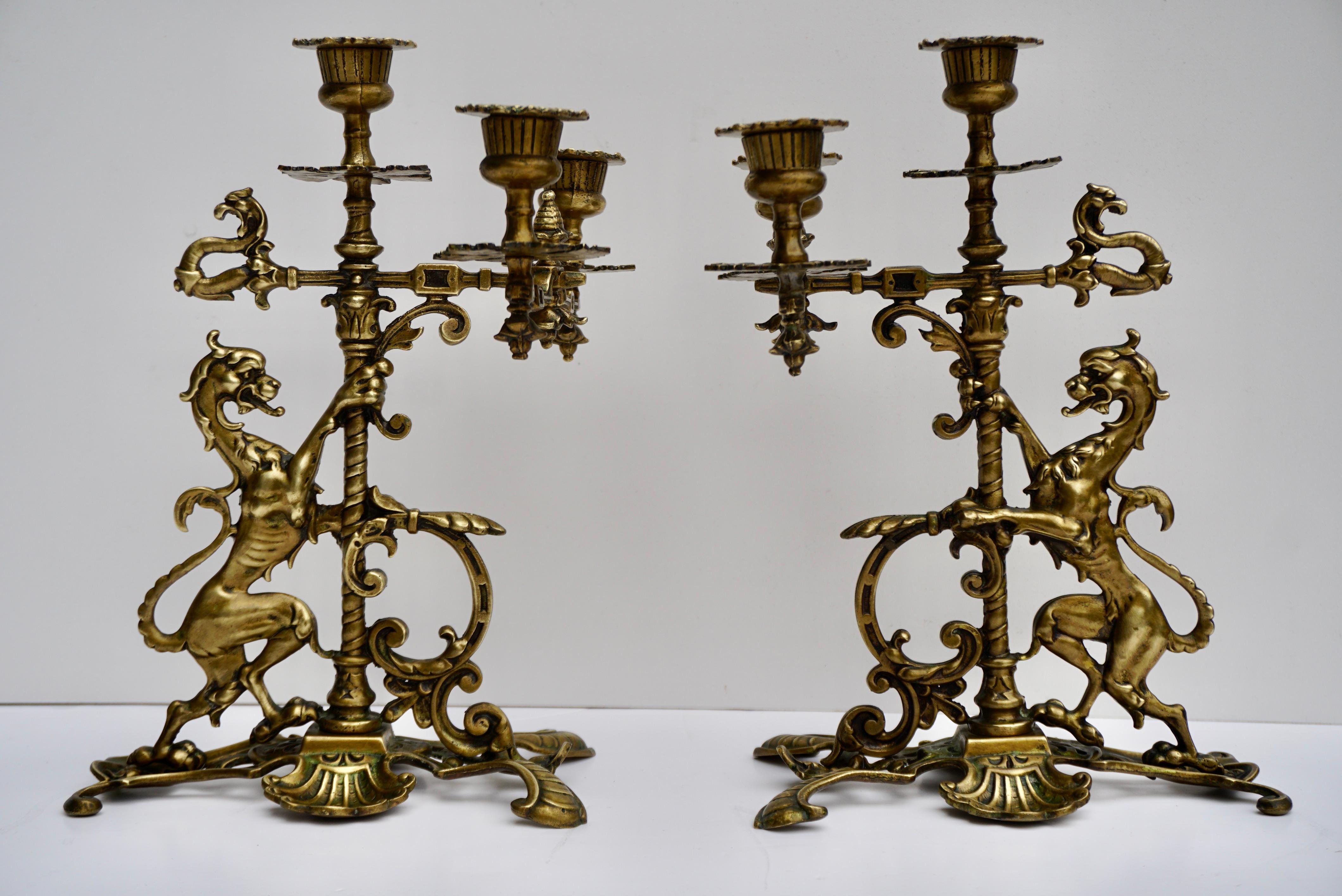 Two very beautiful exclusive brass candlesticks with 2 arms for 3 candles. Very richly decorated with beautiful dragons. These Antique candlesticks are Solid Brass with a 2 dragon / serpent creature motif and lion paw feet. This pair is very unusual