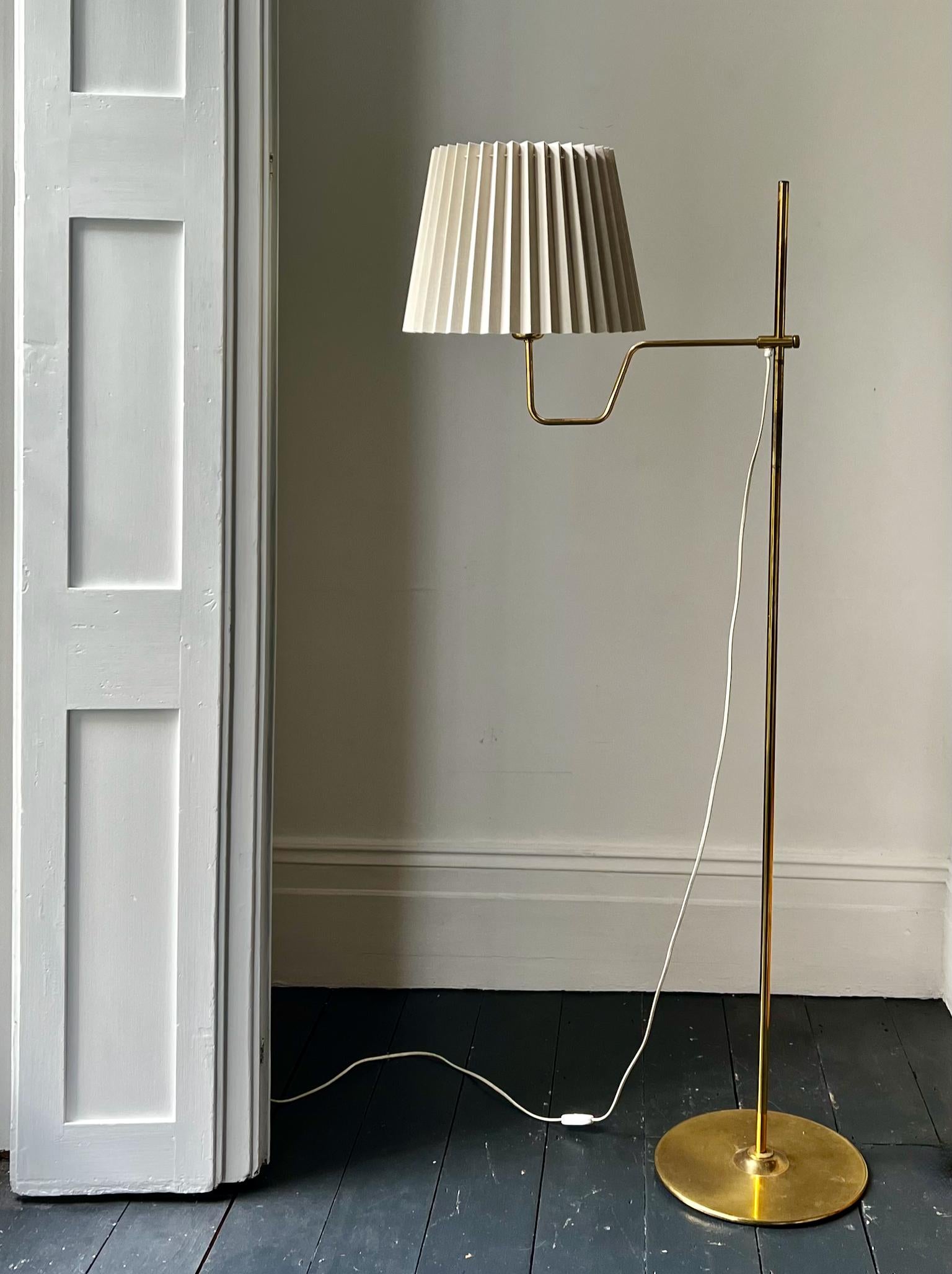 A pair of floor lamps in brass by Hans Agne Jakobsson, and made by his company in Markaryd, Sweden, mid-20th century. 

A simple design with a height-adjustable brass arm and a weighted base. The brass is in good vintage condition with