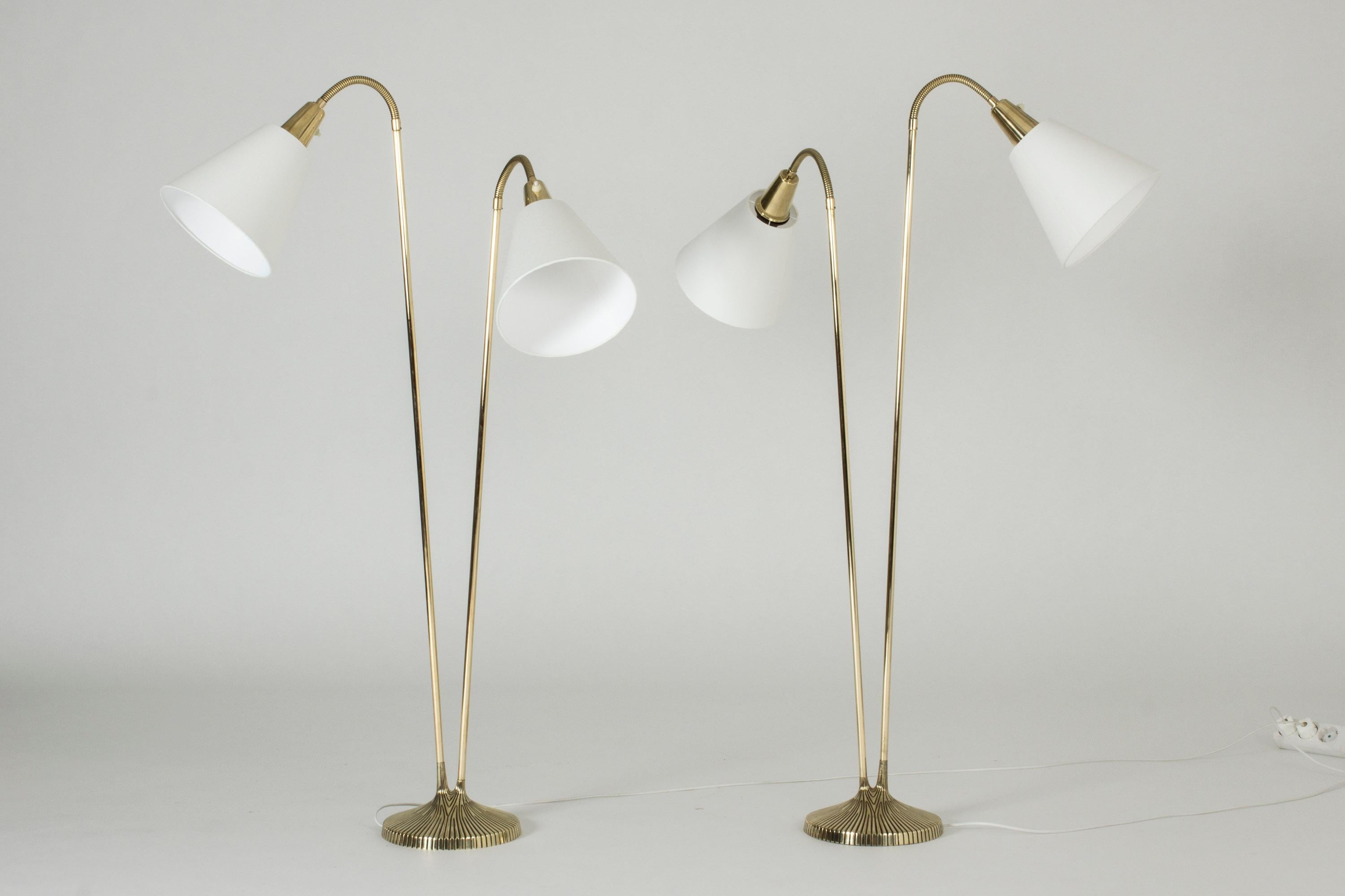 Pair of beautiful brass floor lamps by Sonja Katzin, each with two lamp shades, shooting up from a round base. The bases are embossed with a tree bark-like pattern and the bases of the handles look like twigs with slightly different lengths.
