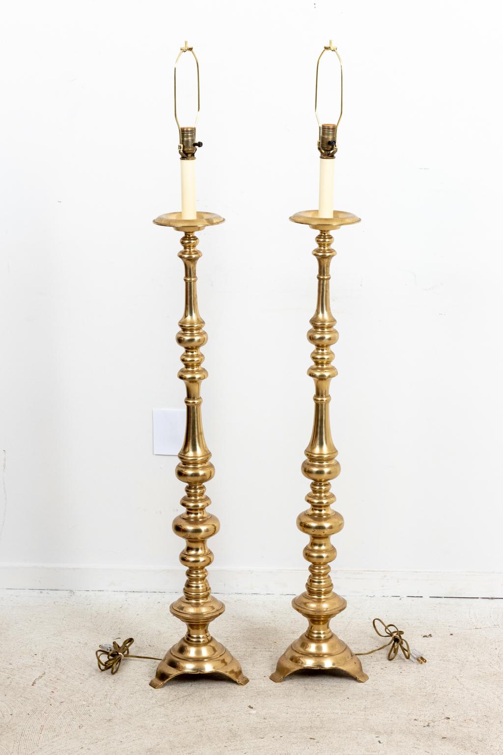 Circa 1960-1970s pair of Brass floor lamps in the Hollywood Regency style. The base measures 8.00 Inches by 8.00 Inches by 50.00 Inches. Please note of wear consistent with age. Shades not included.