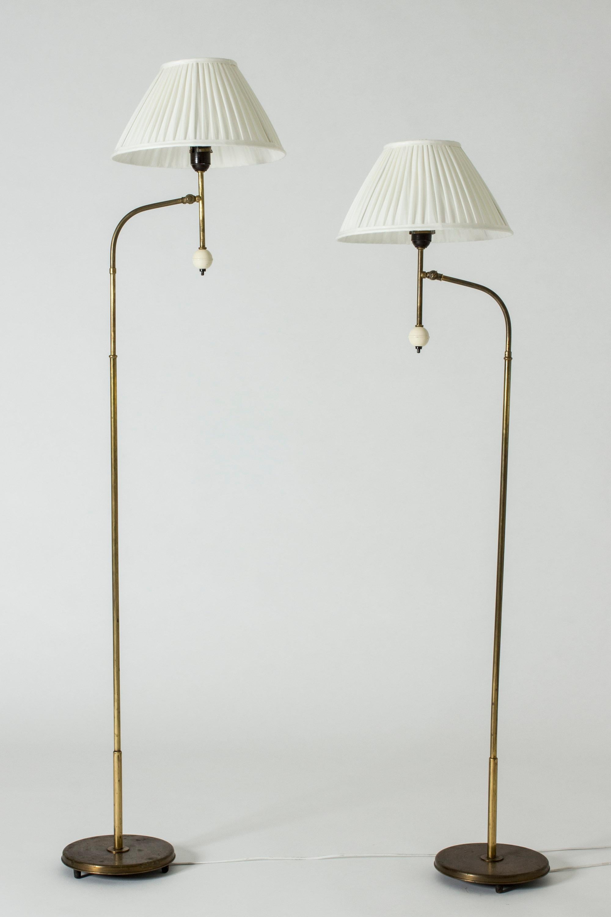Pair of cool floor lamps by Bertil Brisborg, made from brass. Decorative and fun ball-shaped light switches. Adjustable heights, the possibility of adjusting the angle of the shades.

Size: Height 134-172 cm, width 47 cm, depth 32 cm.