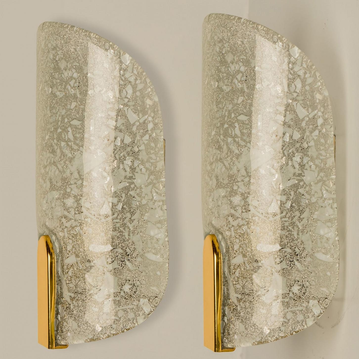 Paire d'appliques en verre de glace épais et texturé, conçues en Allemagne vers les années 1960. Ces appliques murales sont fabriquées à la main et sont de haute qualité.

Illumine magnifiquement. L'élégance intemporelle de l'applique murale confère