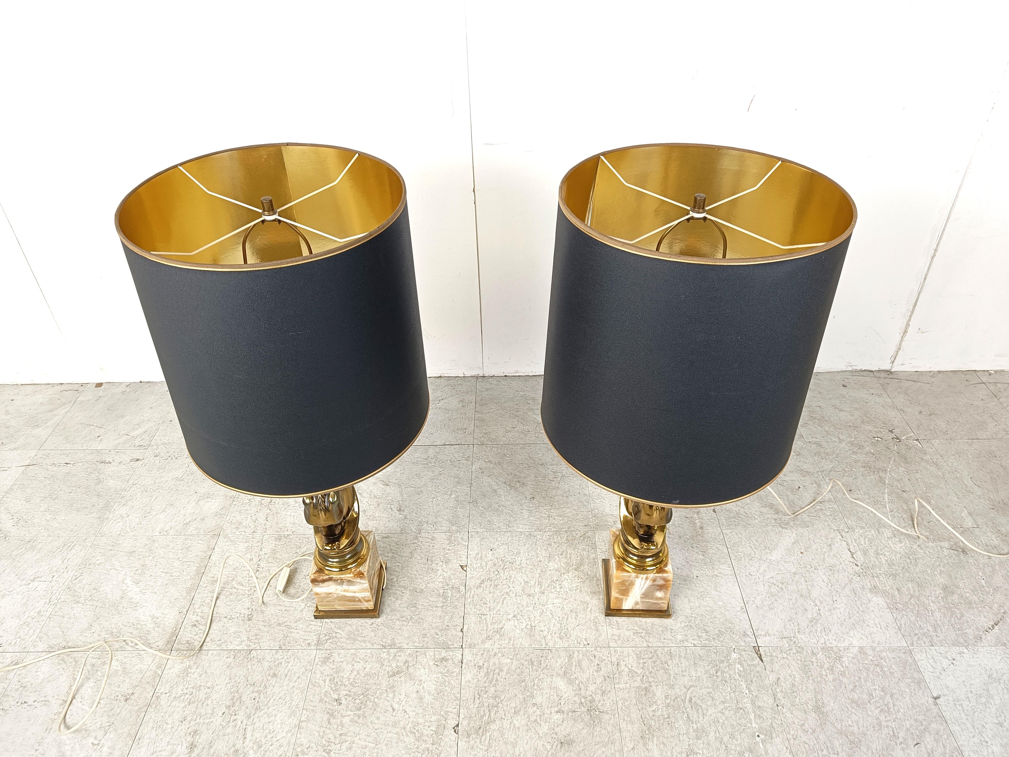 Pair of vintage horse head table lamps from Deknudt.

Hollywood regency style.

Made out of 24kt gold plated metal and onyx marble bases.

To be used with a regular E27 light bulb.

Beautiful cylindrical lamp shades with a gold finish on the