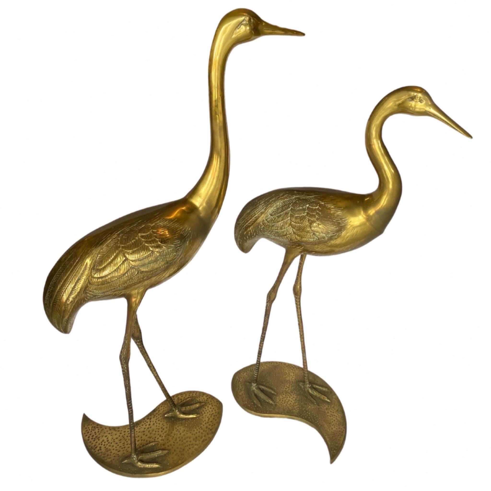 Two Brass Cranes with Nestling Bases, in the style of Hollywood Regency.

Fine Etching Details Thoughout.

Base has a “Yin & Yang” Shape.

Maison Jansen (Manufacturer).