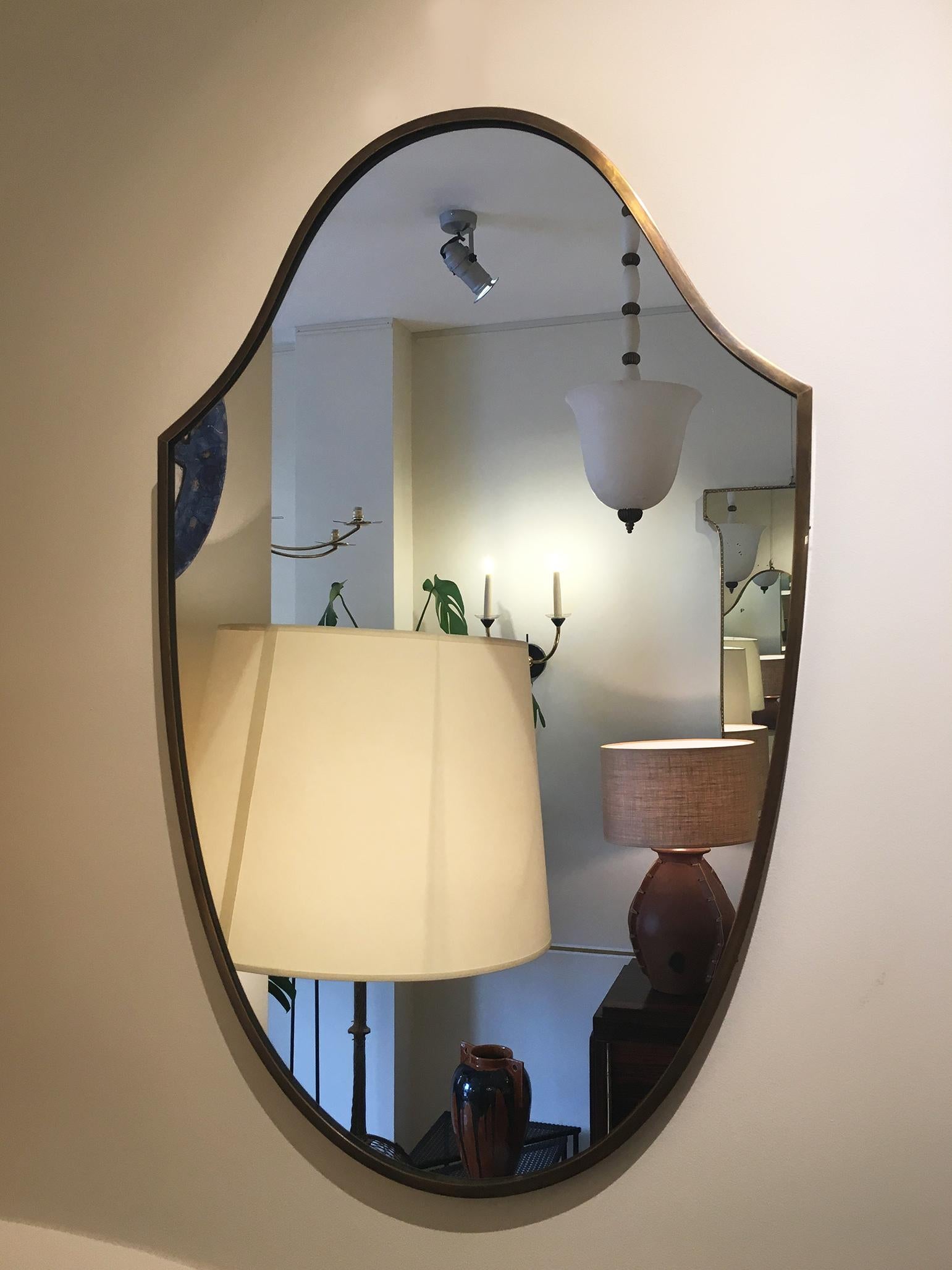 A pair of brass shield shaped mirrors
Italy, circa 1950.