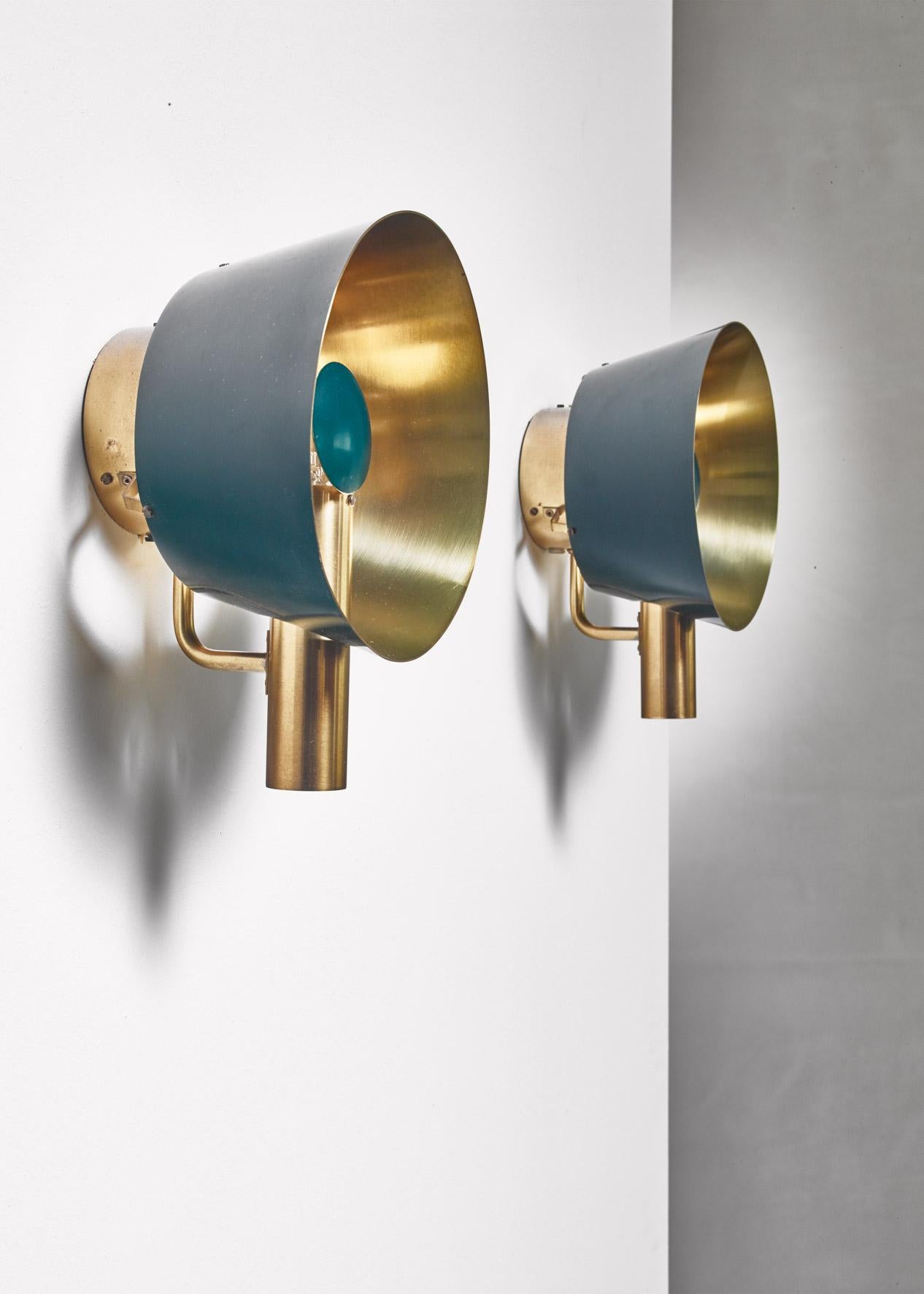 A pair of brass wall lamps, partly lacquered green, by Lyfa. The lamp has a adjustable deflector in front of the light bulb.

Labeled by Lyfa and in a wonderful condition.