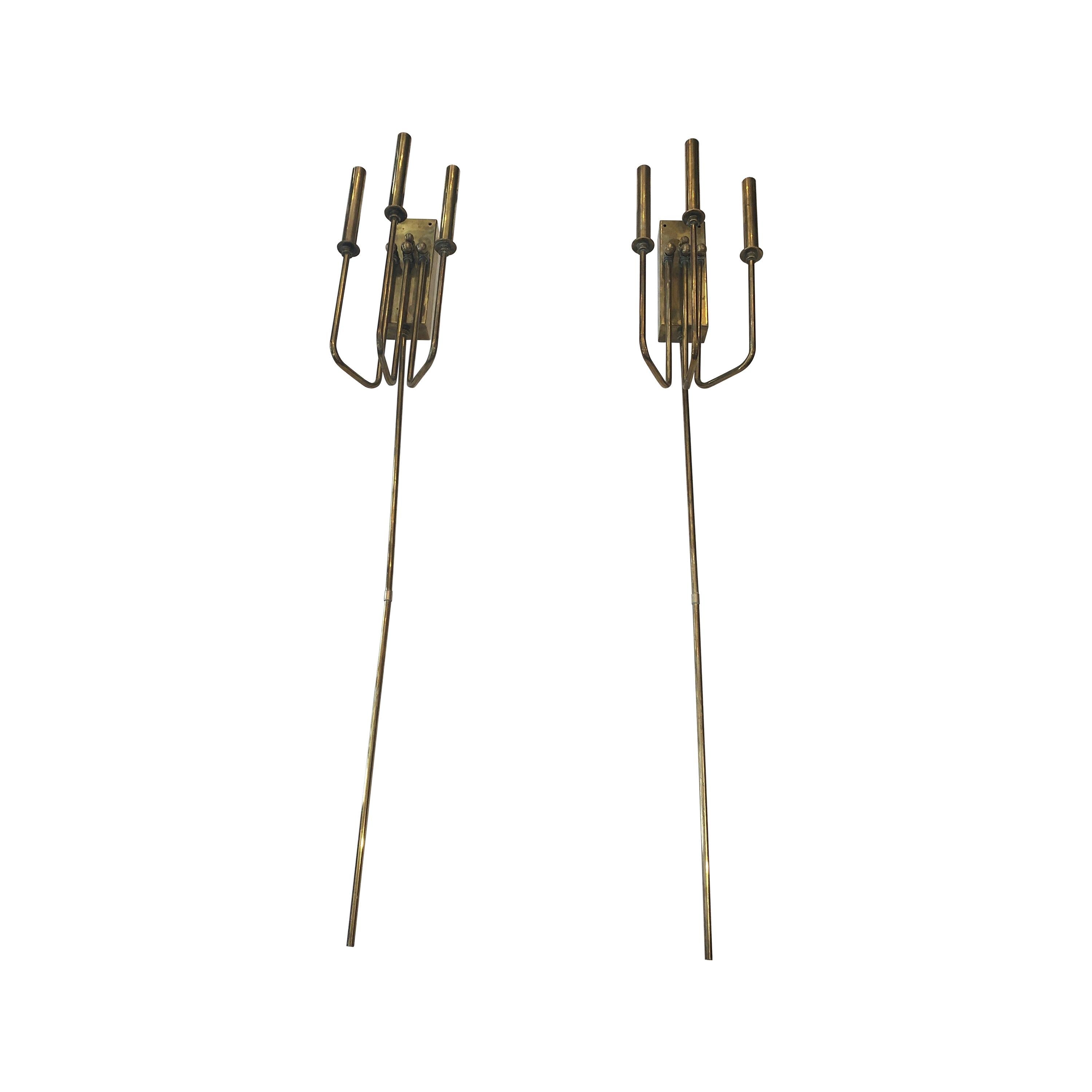 A chic pair of elongated brass Italian Mid-Century Modern wall sconces having 3 arms each and dimmers.