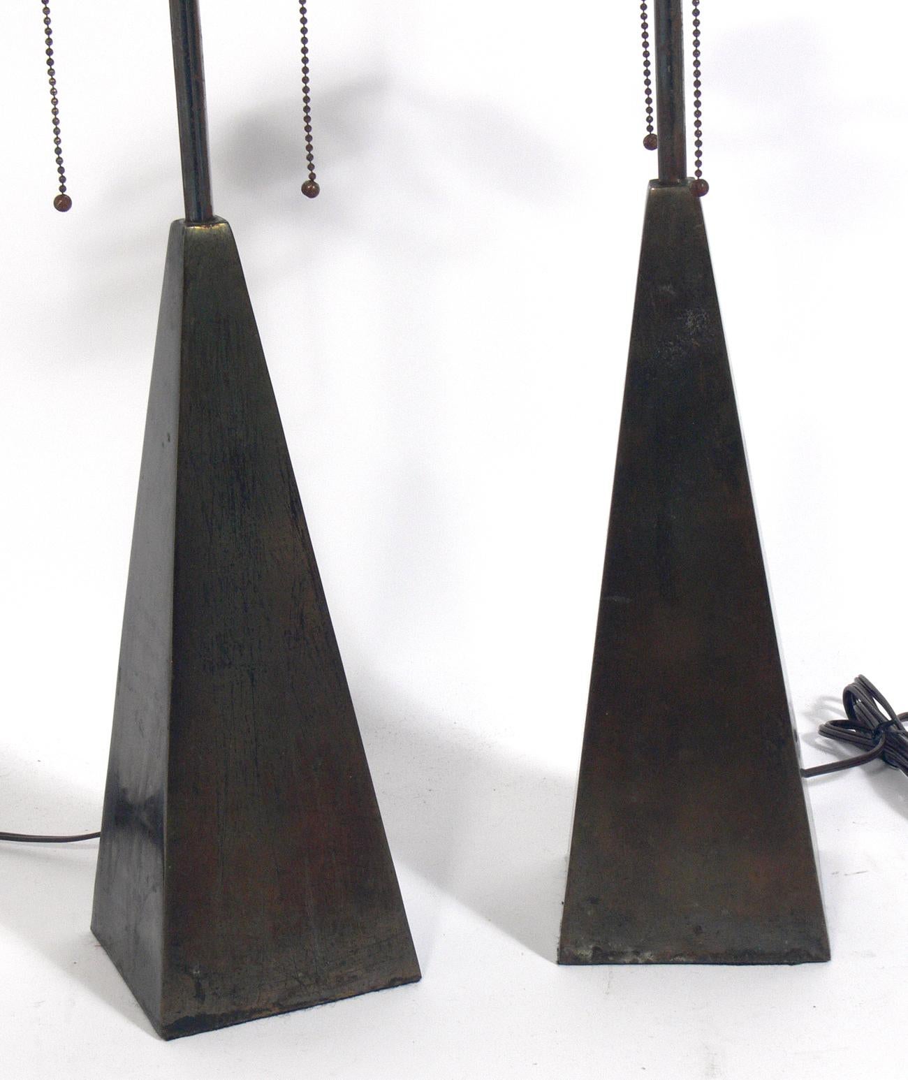 Pair of brass Obelisk lamps, American, circa 1960s. They retain their original distressed bronze color patina. They have been rewired and are ready to use. The price and measurements noted includes the shades.