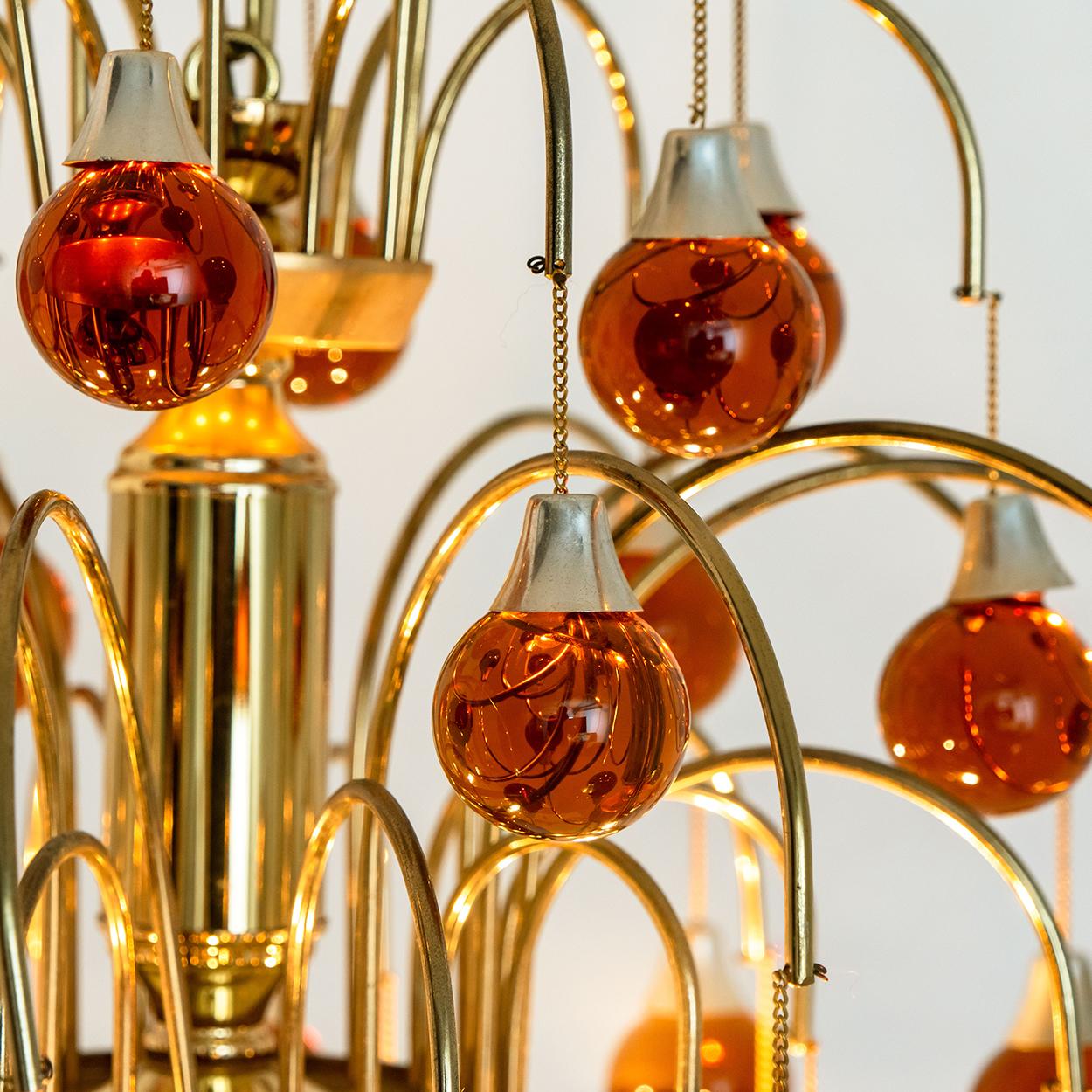 Pair of lovely Murano chandeliers whit dark 36 orange glass balls on a chain. With brass frame. Illuminates lovely
An exceptional set that you don't see often! A rare opportunity.

In very good vintage condition. Drop chain can be adjusted as