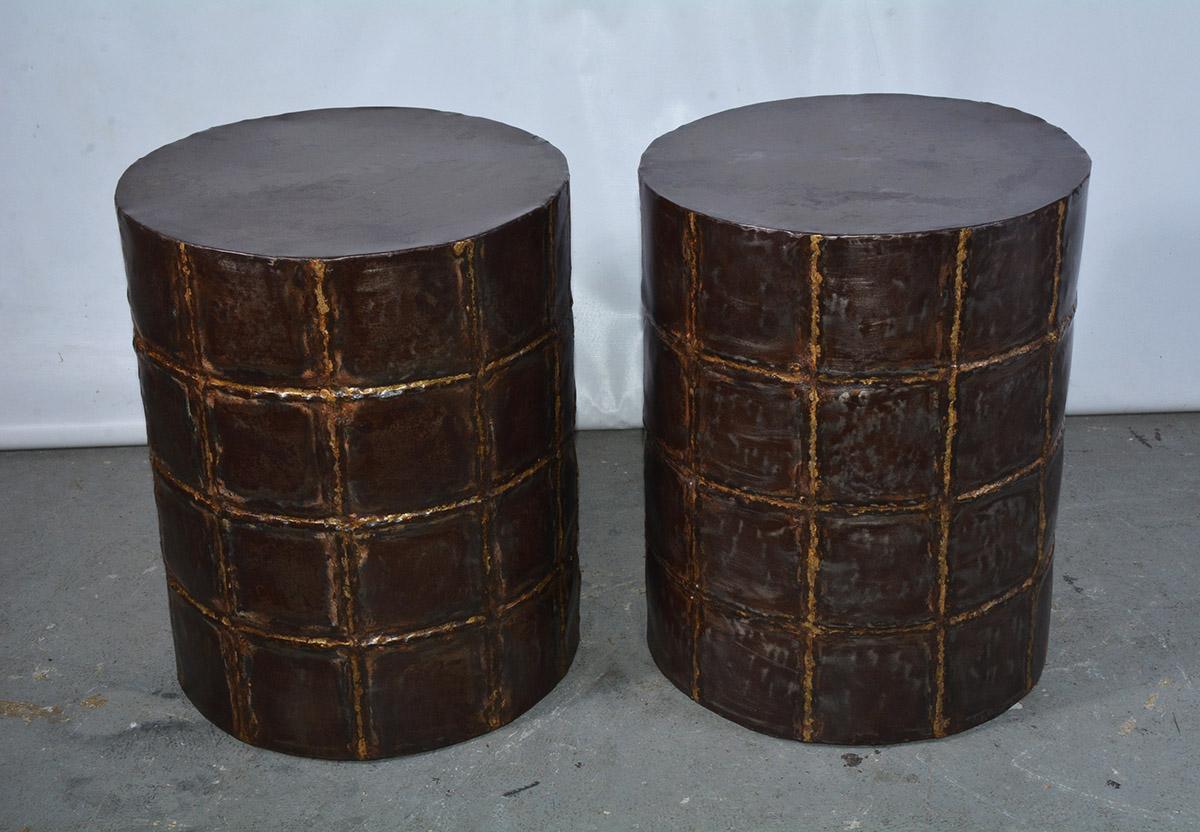 The brass garden seats, stools or side tables in the shape of a drum are hand-soldered in a patchwork-like pattern. The metal has been given a darkened finish.
These table or stools can be used as plant stand, side table or for extra seating.