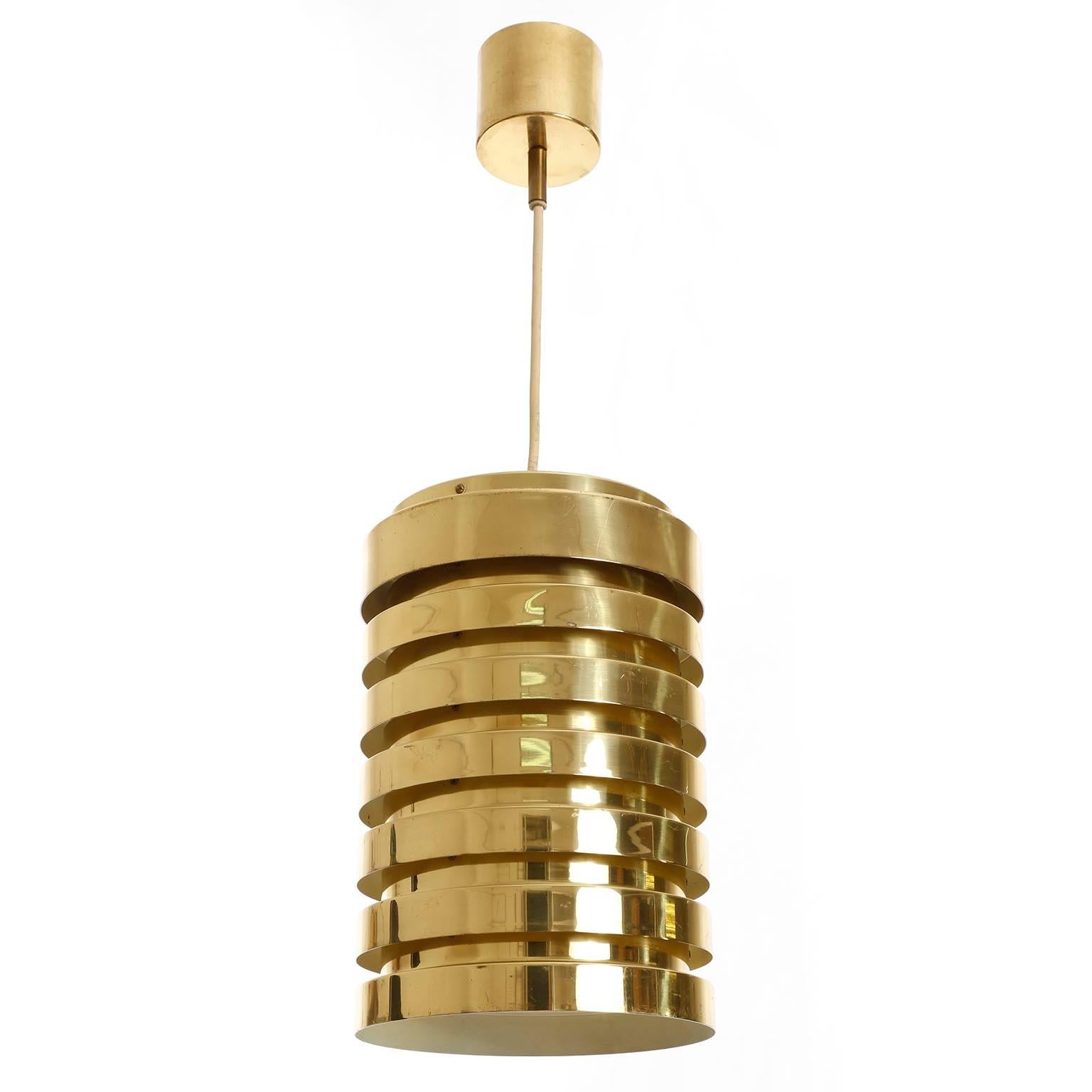 A pair of Mid-Century Modern cylindrical and polished solid brass pendant lights designed by Hans-Agne Jakobsson and manufactured by AB Markaryd circa 1960.
The inside is painted white, aged and thus a bit yellowed.
The height of the body without