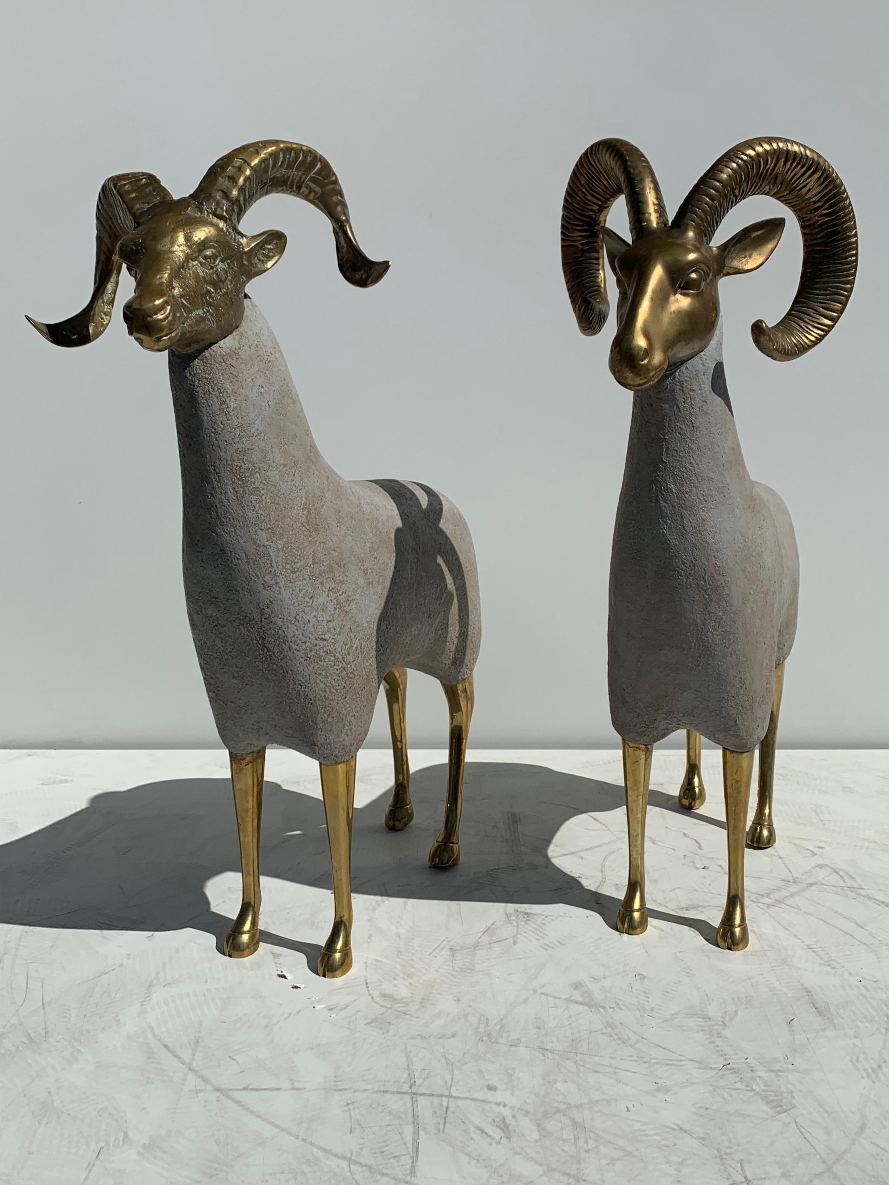 Pair of brass ram or mountain sheep sculptures in the style of Lalanne.  Solid brass heads are vintage from 1970s and retain original patina. Body is newly made of wood and covered in papier mâché to look like concrete (not suggested to keep it on