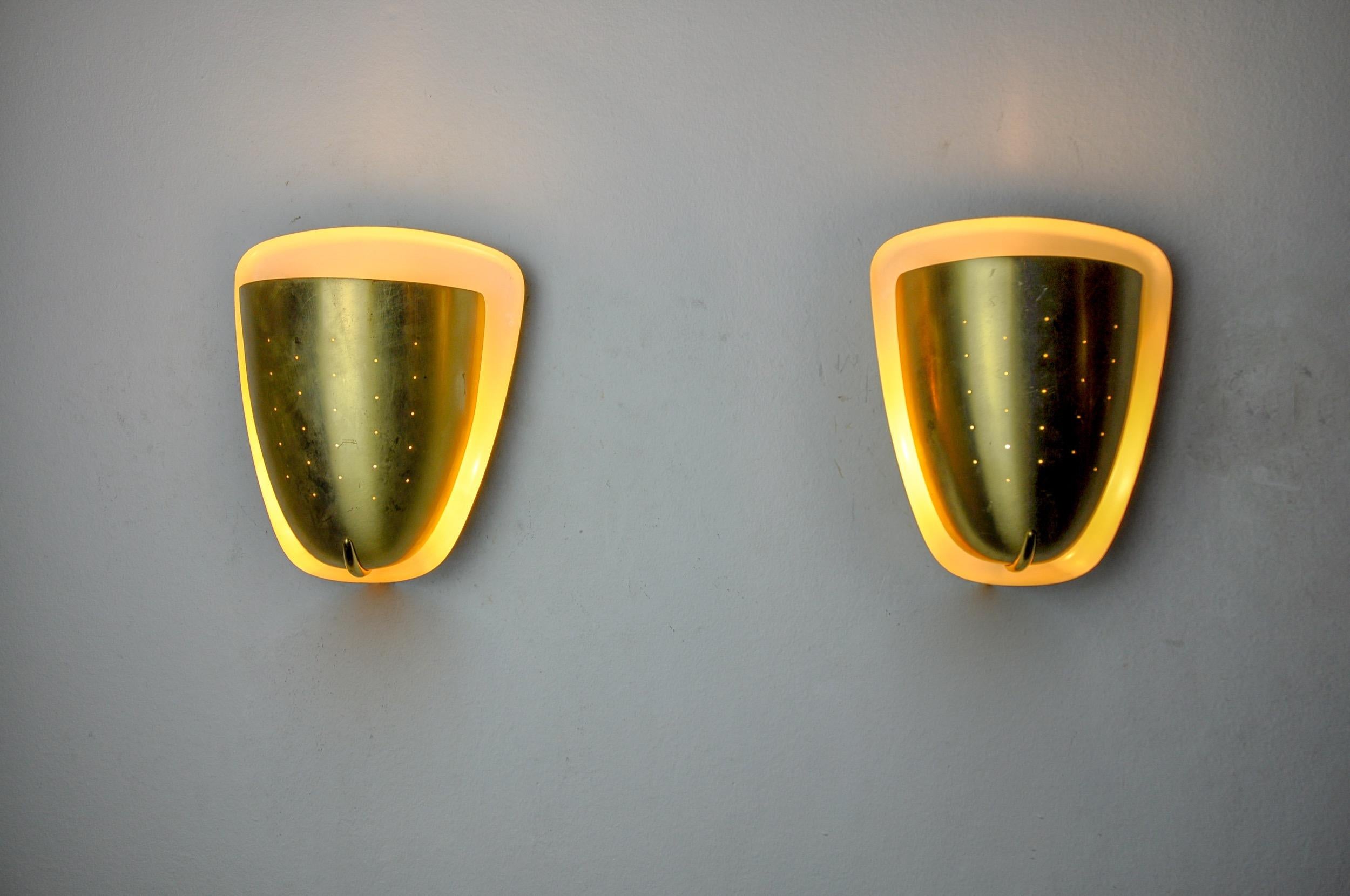Very beautiful and rare pair of regency wall lamps in brass designated and produced in italy in the 1970s. Gilded brass structure and white interior creating a beautiful play of light. These sconces will perfectly illuminate your interior. Very nice