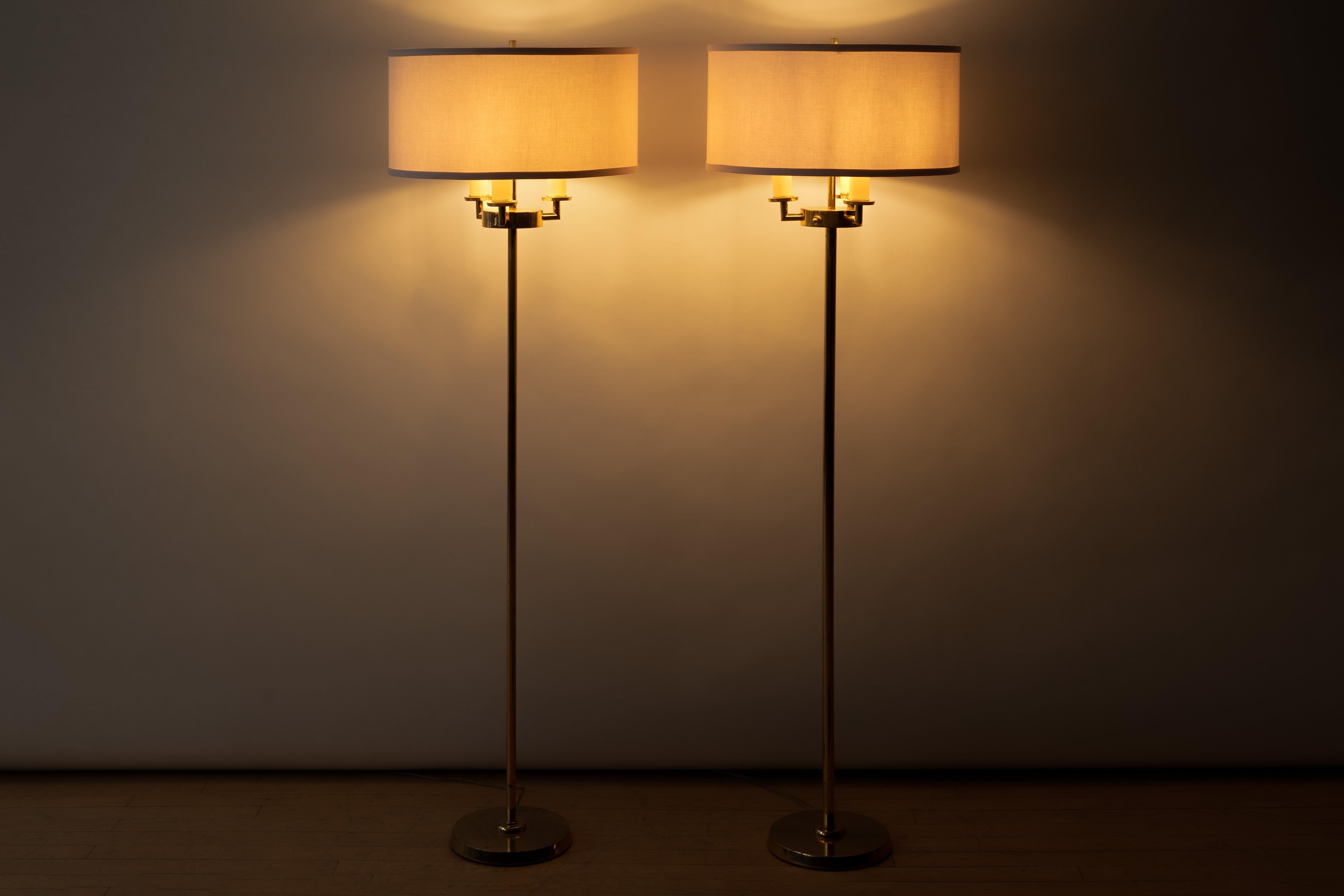 États-Unis, vers les années 1950. Une élégante paire de lampadaires Likno du designer anglais T. H. Robsjohn-Gibbings pour Hansen. Chaque lampe est fabriquée en laiton massif de haute qualité et comporte trois bras - chacun avec une douille -