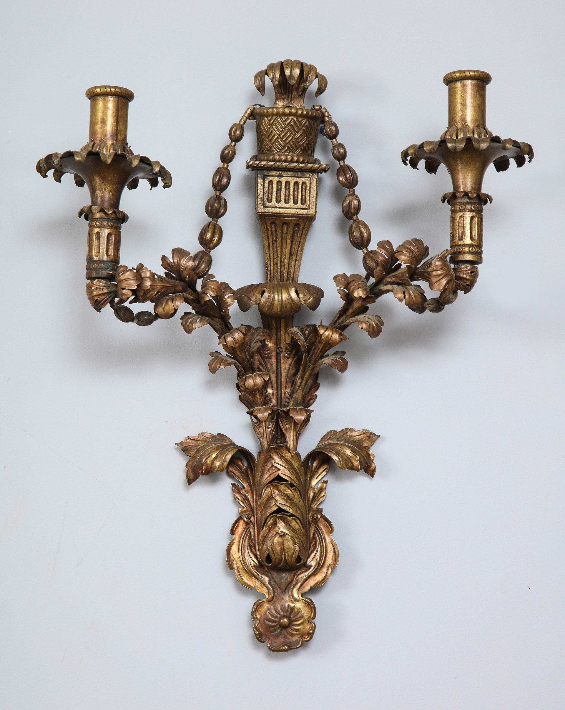 Hammered brass sconces with ornate foliate design.