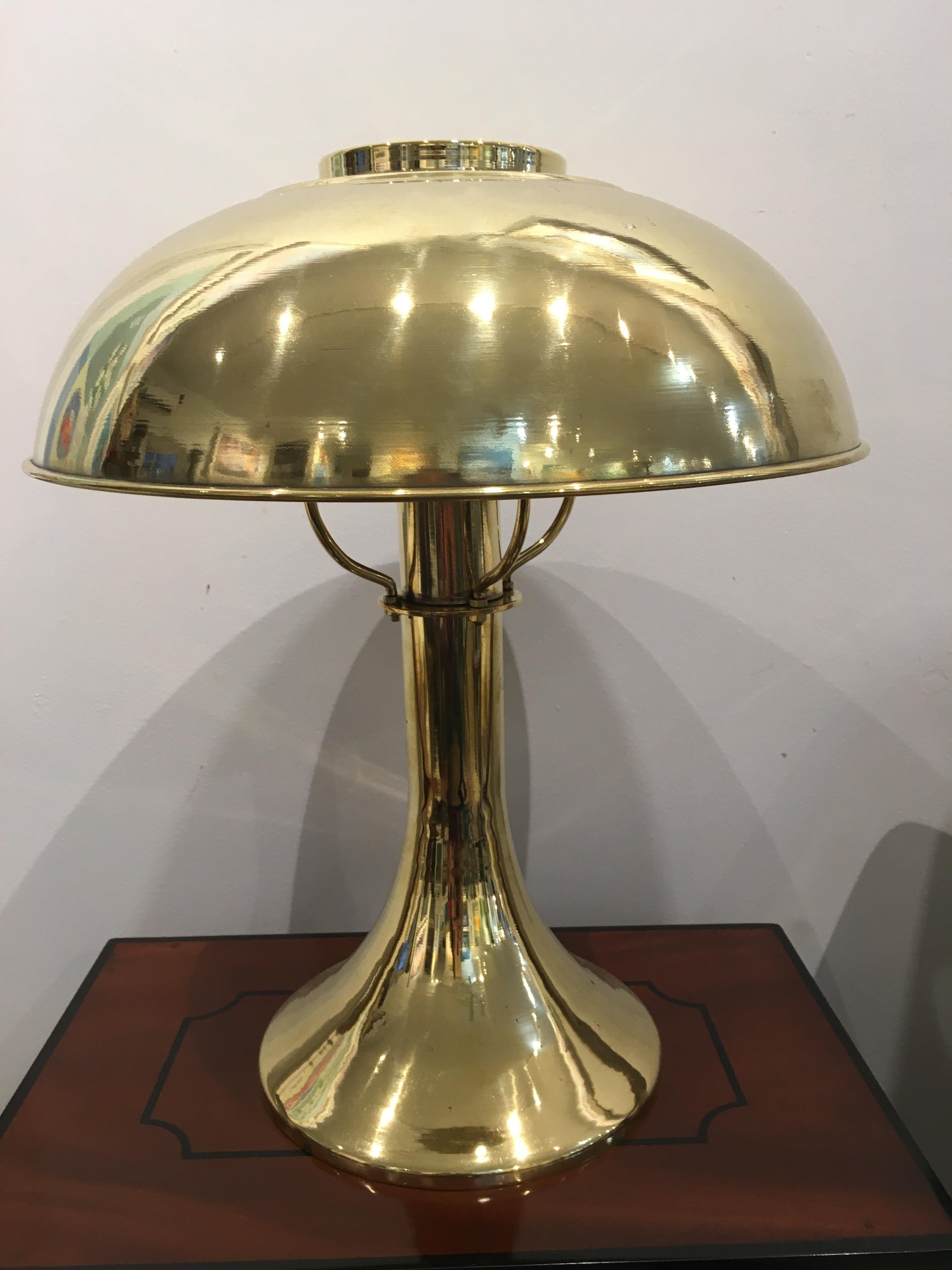 From a ship's stateroom, a pair of brass table lamps with elegant fluted base and domed brass shades. Brass has been polished and rewired for American use, originally European. Takes one standard size light bulb. Mid-Century Modern. Base has an 8