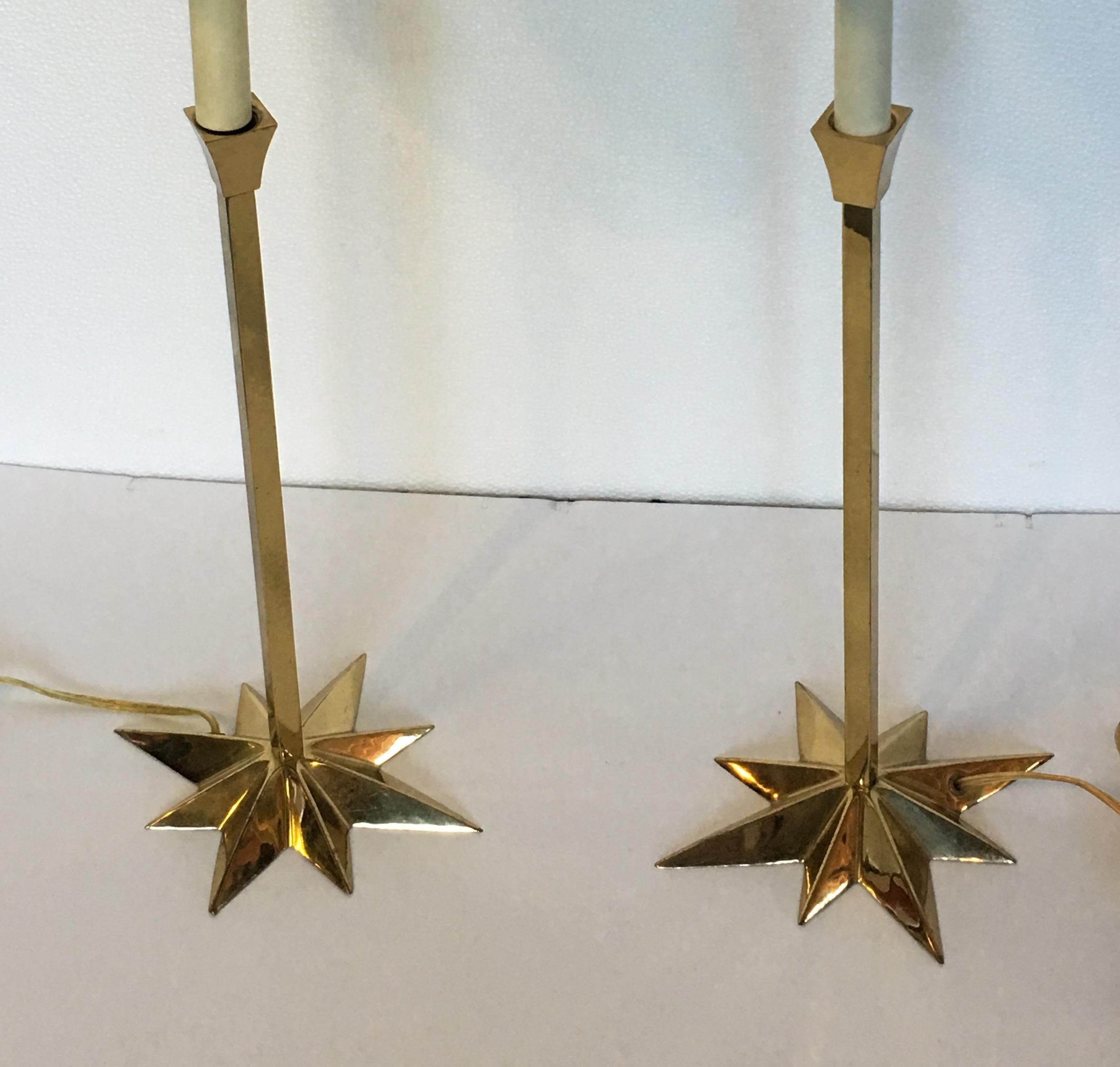 Pair of elegant brass candlestick style side lamps, with clip-on pleated linen shades. The base is brass in the shape of a star.
Measures: Base width is 6