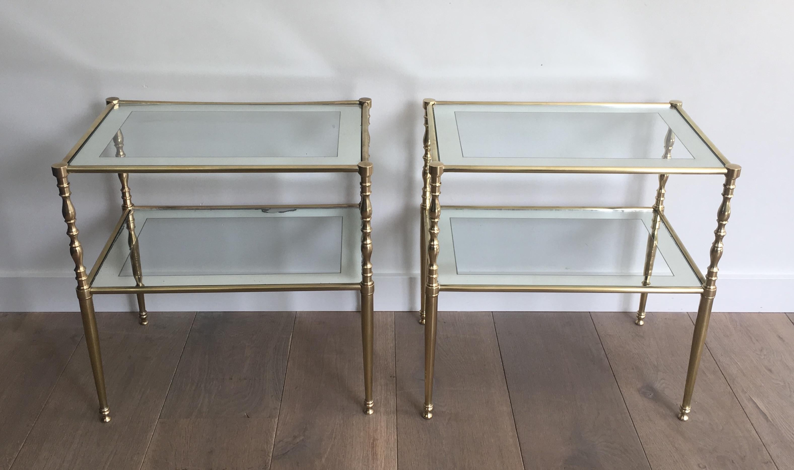 This very elegant pair of side tables is made of brass with clear glass shelves surrounded by a silvered mirror. line French, circa 1970.