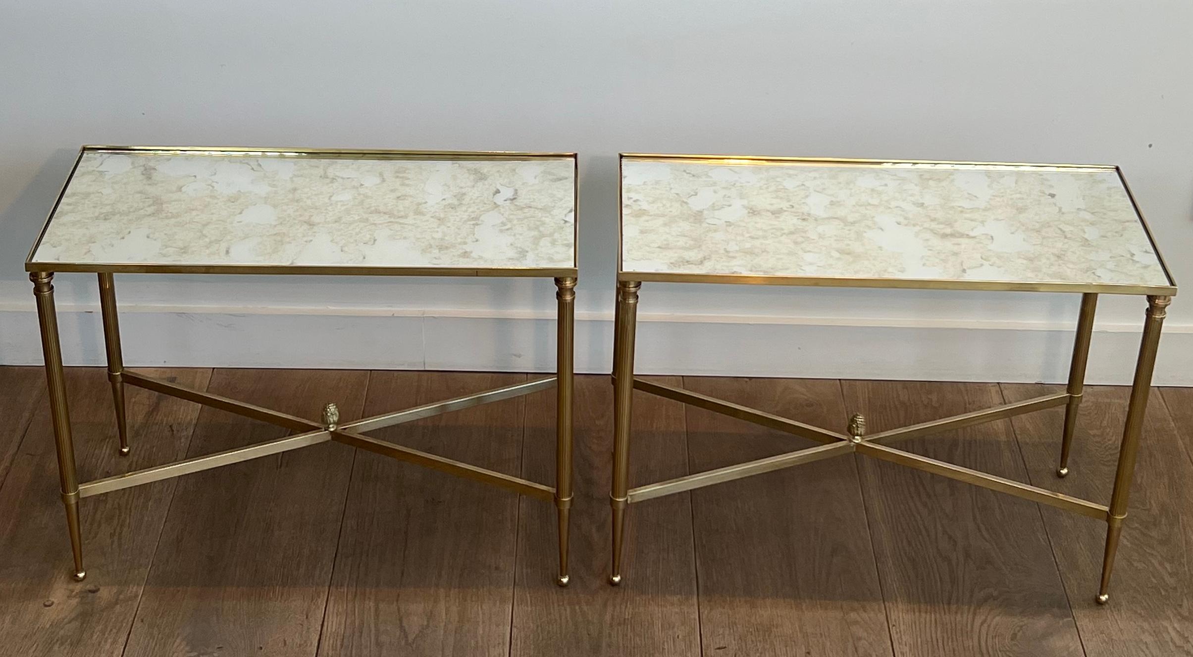 Questa bella ed elegante coppia di tavolini in stile neoclassico è realizzata in ottone con gambe scanalate e piani in specchio ossidato. Questa è un'opera francese di Maison Jansen. Circa 1940