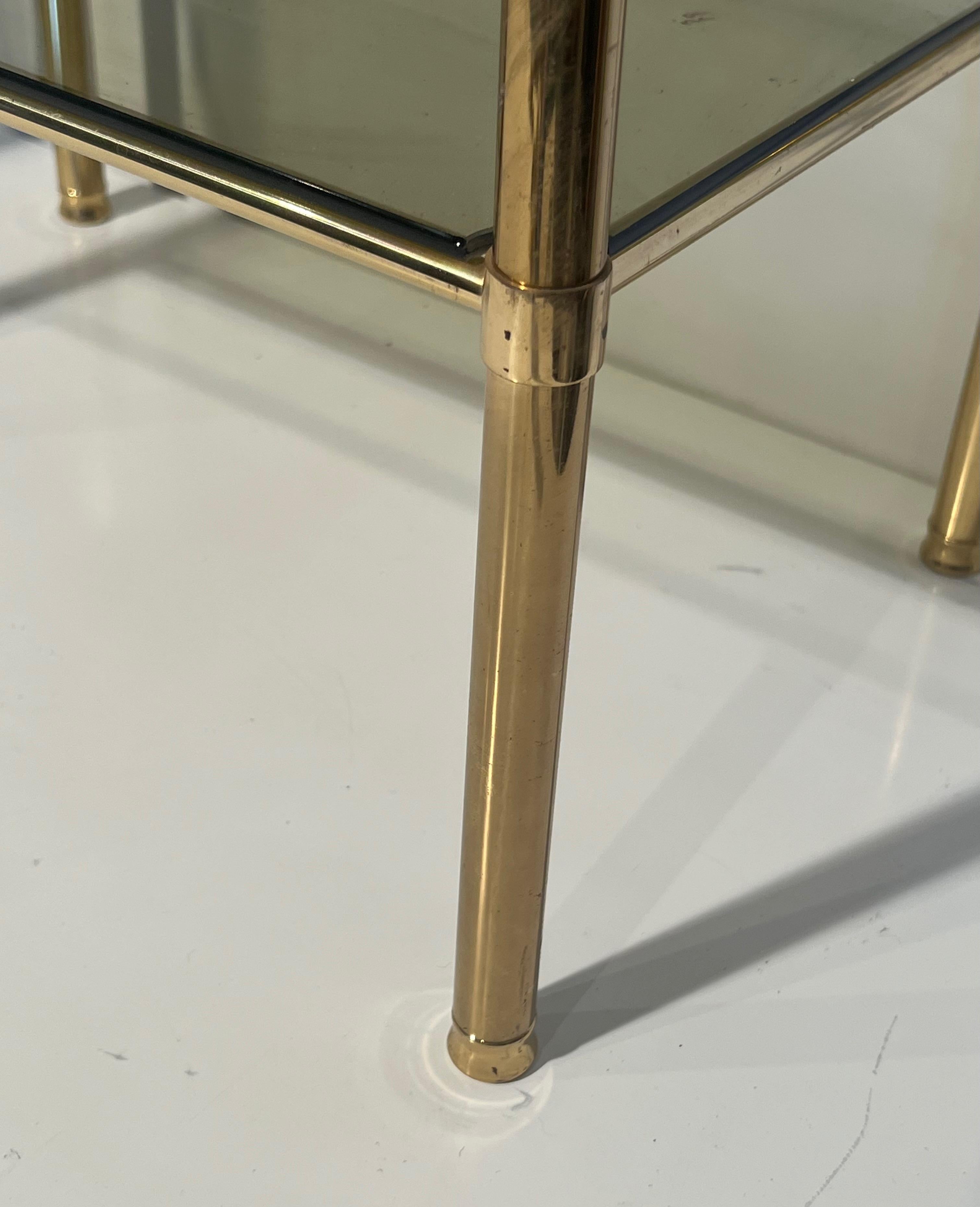 Effet bronze Paire de tables d'appoint en laiton avec étagères en verre fumé. Travail en français. Circa 1970 en vente