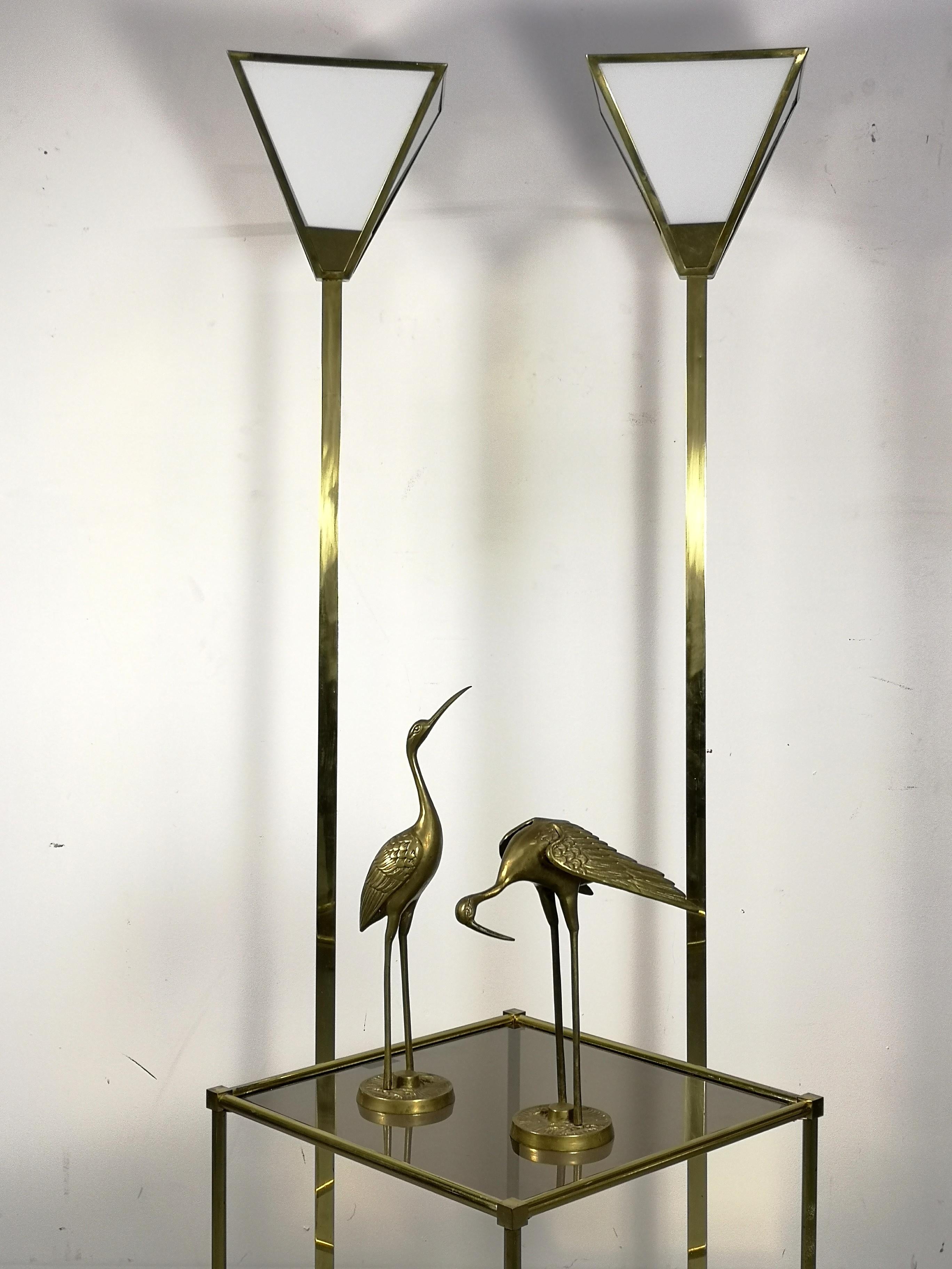 Rewired with black and copper fabric wite, these pair of brass standard lamps feature white glass shades, 1970s.