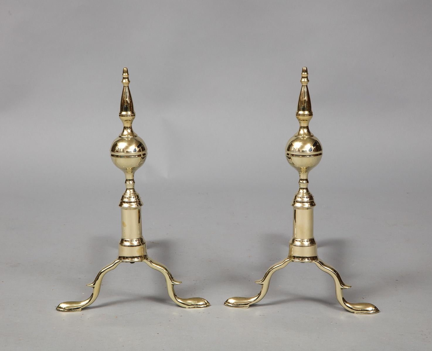 Good pair of brass andirons with steeple tops over ringed ball centres and standing on balustrade shafts with spurred slipper feet.