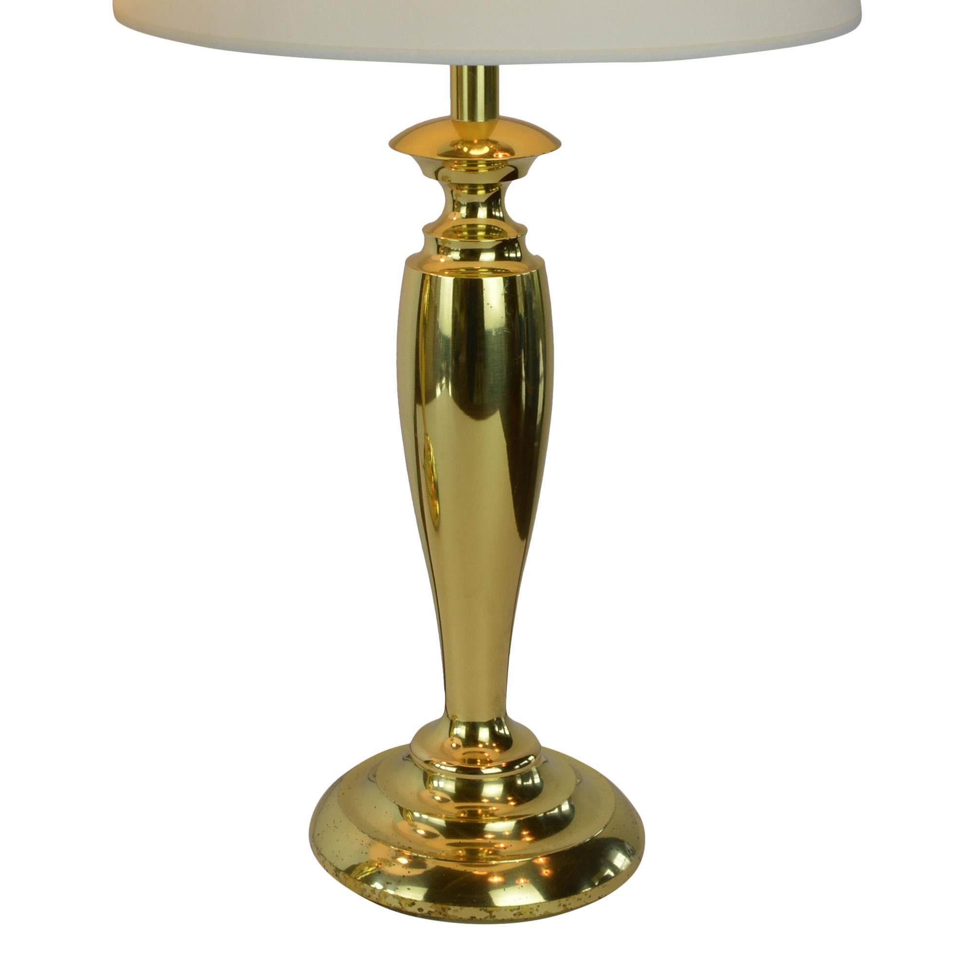 Pair of classic Mid-Century Modern table lamps with new white drum shades are sure to complete a clean modern look in any room. The pair of lamps have the matching finial at top. The manufacturer label is on socket of one lamp.