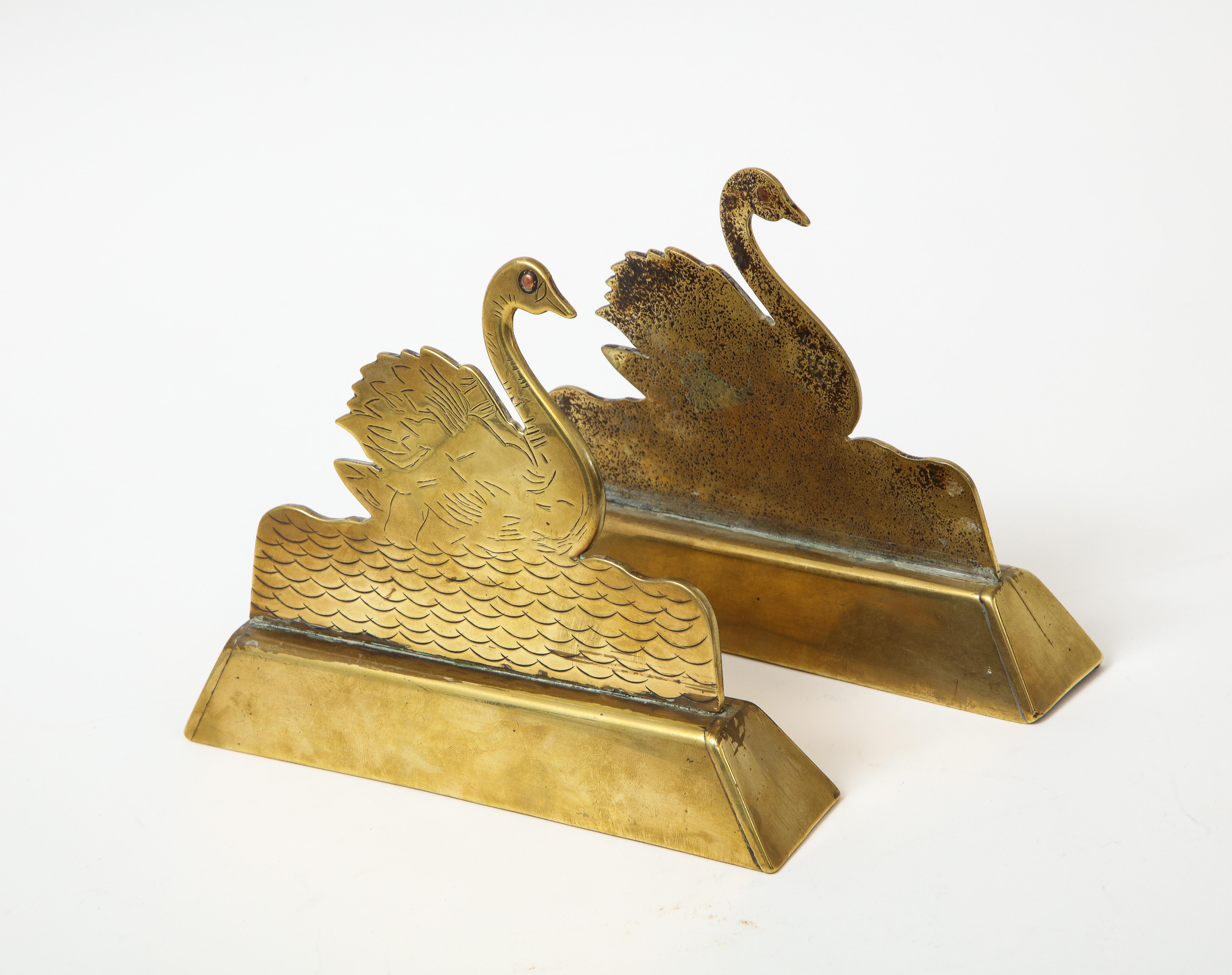 A pair of engraved brass swan mantle ornaments, ca. 1850. Featuring a colorful stone in each swan's eye.
  