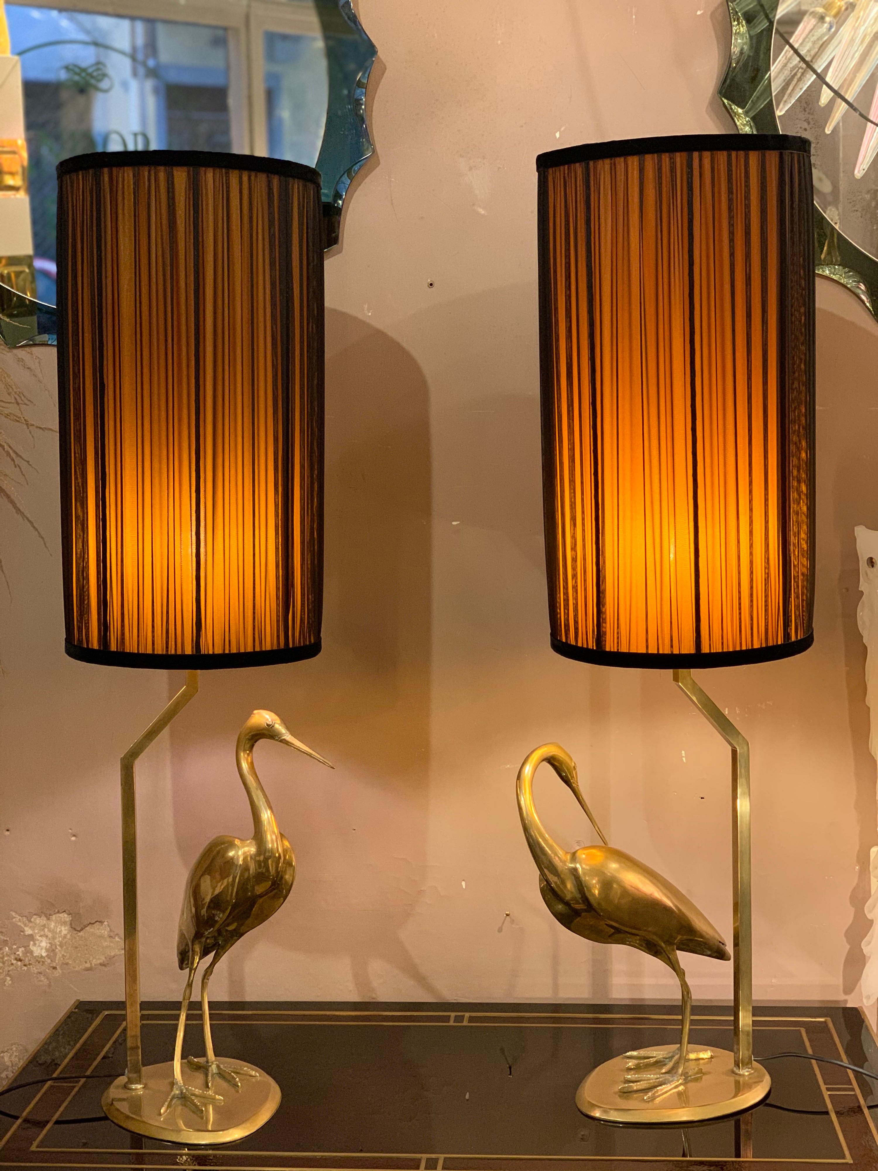 Pair of brass heron sculpture table lamps with double color handcrafted lampshades, when the light is on the two colors (gold inside and black outside) mix each other creating an amazing effect.