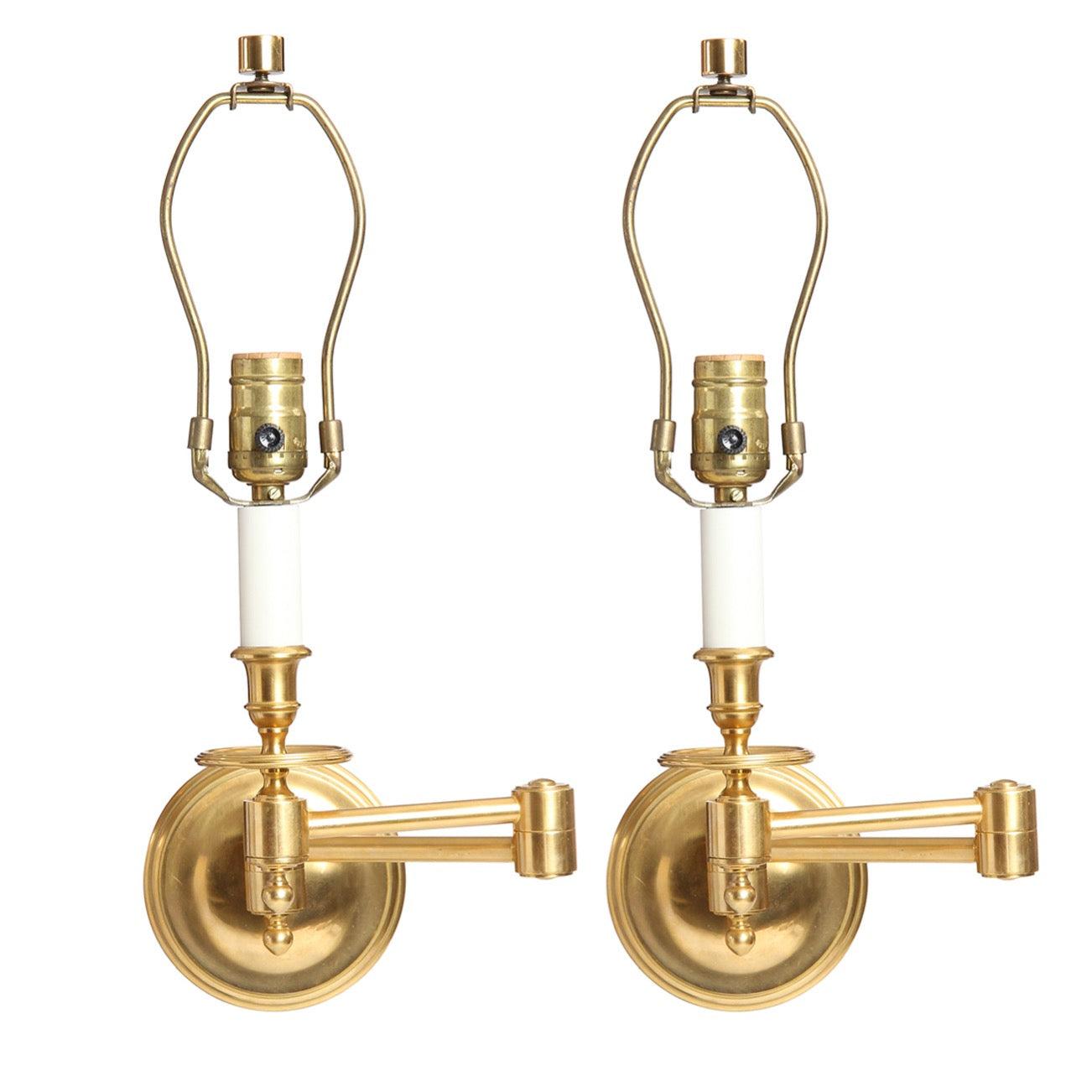 Pareja de apliques o candelabros de pared de latón pulido y lacado con placas de montaje redondas escalonadas.
