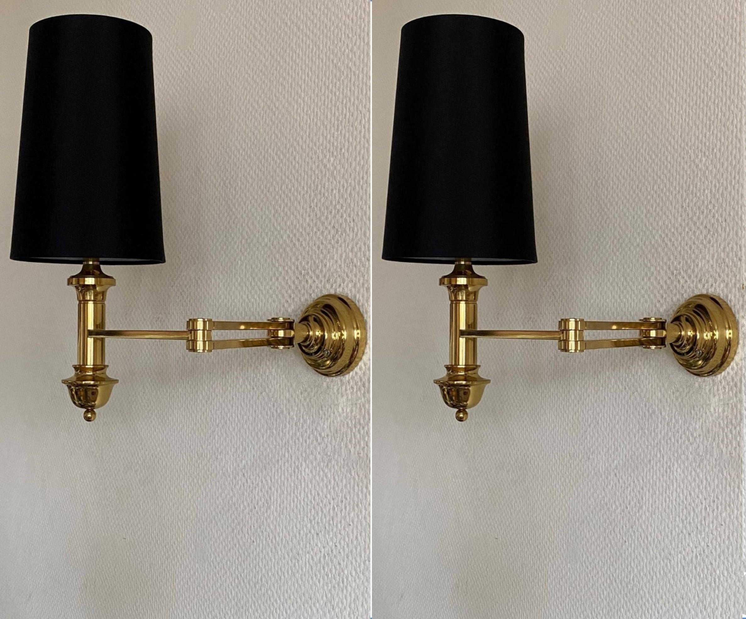 A pair of high-quality solid brass swing arm wall lamps in Maison Jansen style, France, 1960s. Precise craftsmanship made of hand-forged polished brass with black linen shades. These wall sconces are design rarities from the 1960s that are no longer