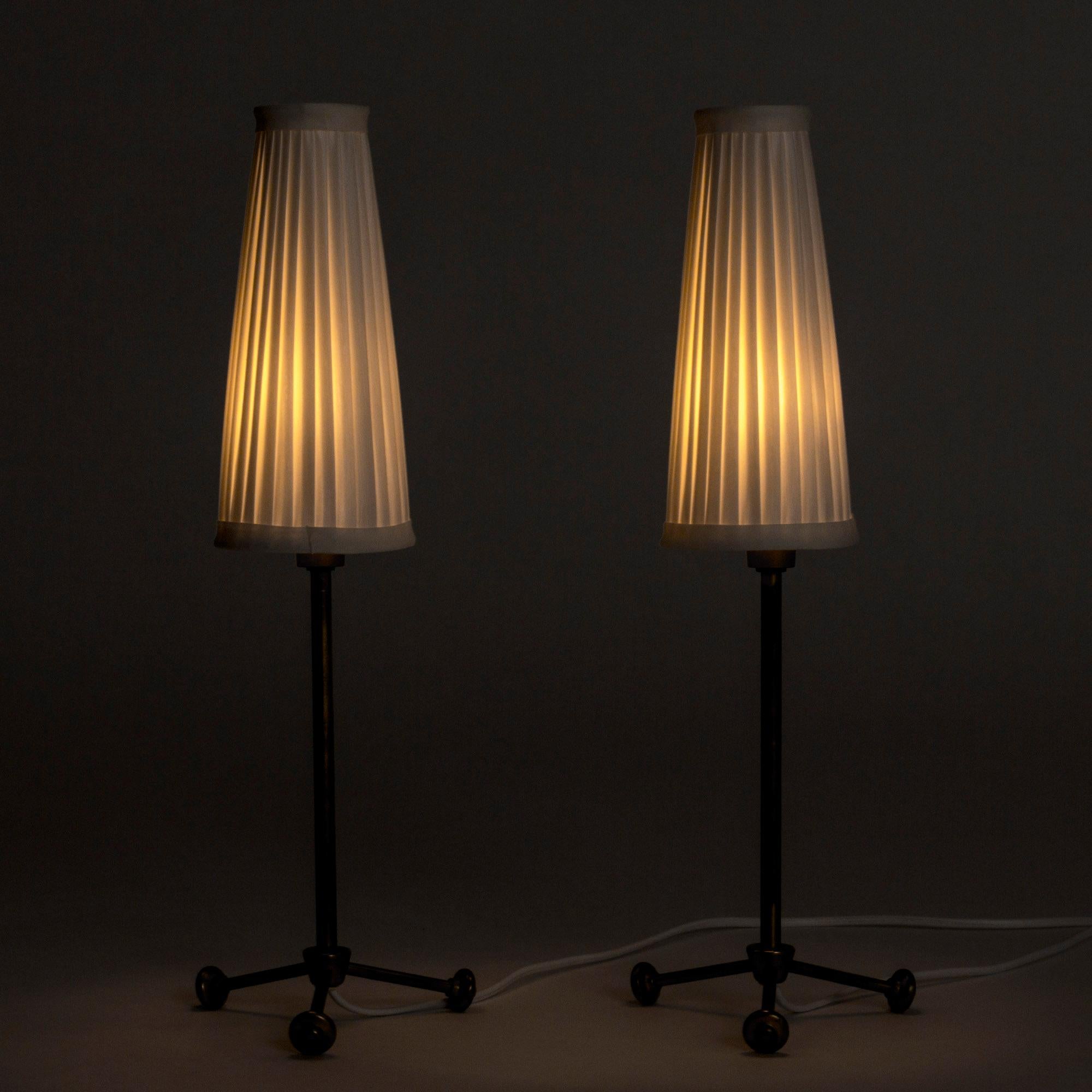 Pair of lovely table lamps by Hans Bergström, made from brass with tall, slender lamp shades. Feet with spheres at the ends.
