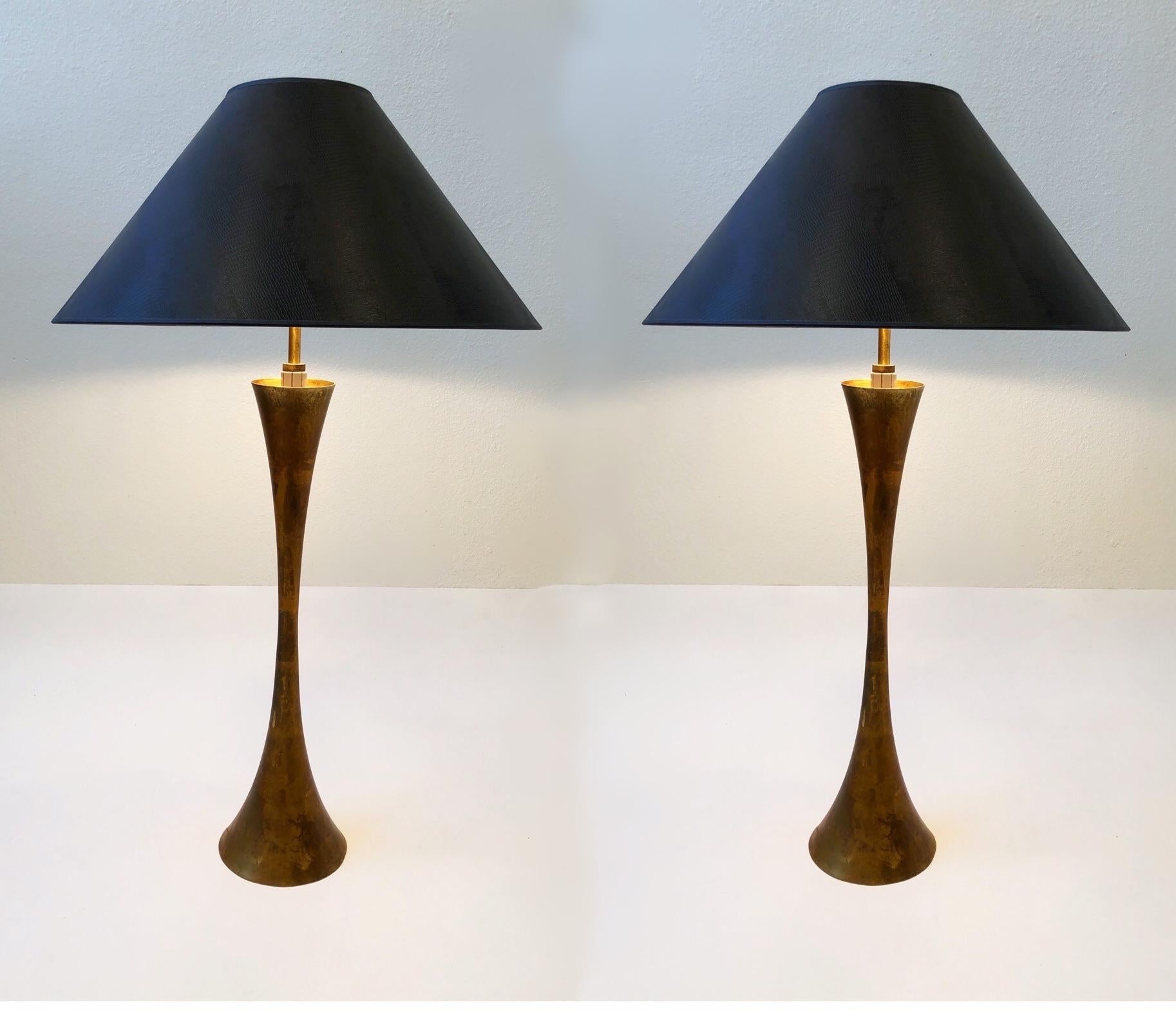 A beautiful pair of brass hourglass shape table lamps designed by Stewart Ross James for Hansen Lighting Co. in the 1950s. The lamps are constructed of solid brass that’s gold leaf gilded. Newly rewired with original three way rotating switch. New