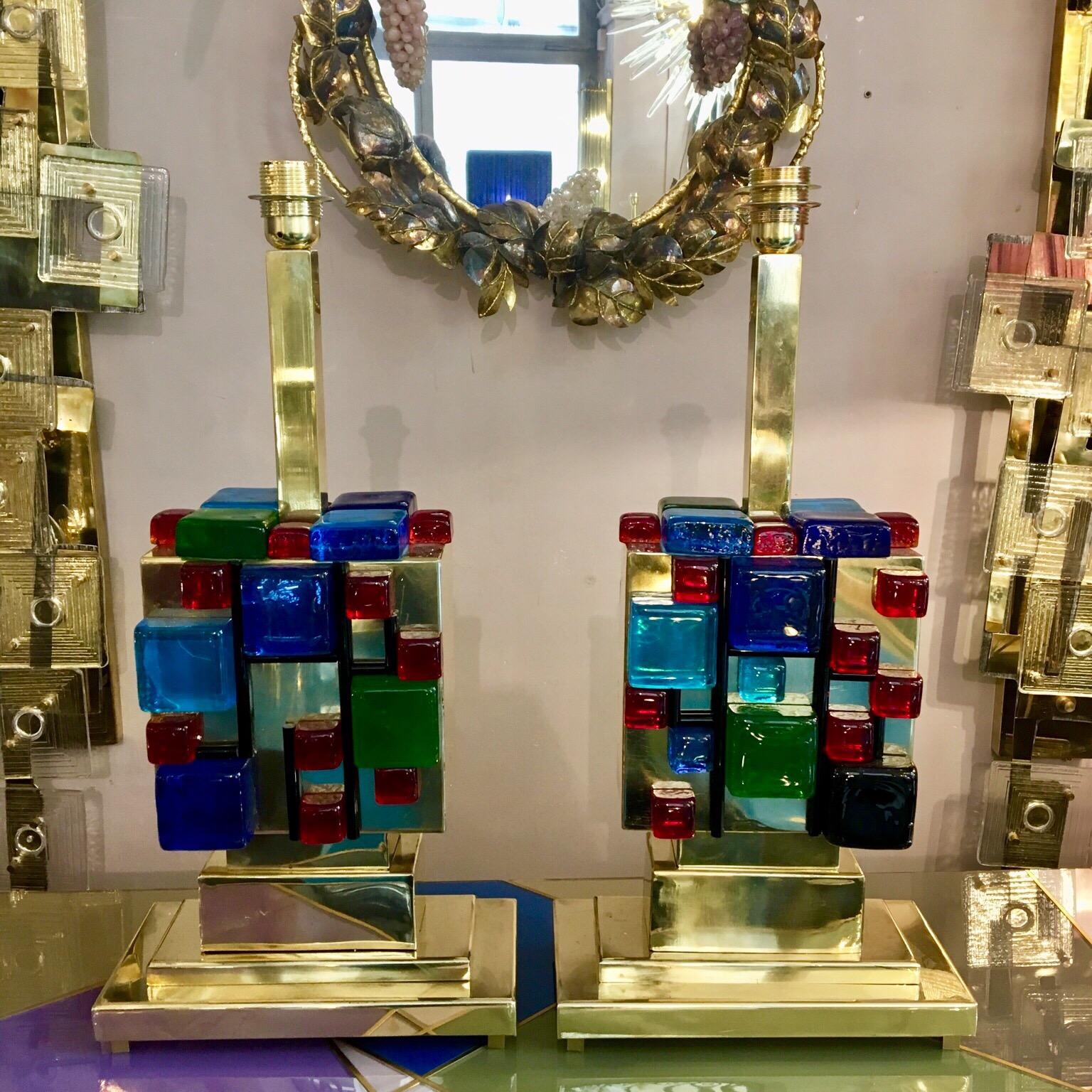 Paire de lampes de table en laiton avec des cubes multicolores en verre de Murano.
Les couleurs vives du verre créent un effet incroyable lorsque la lumière le traverse.
Nous pouvons réaliser des abat-jour avec des designs personnalisés.