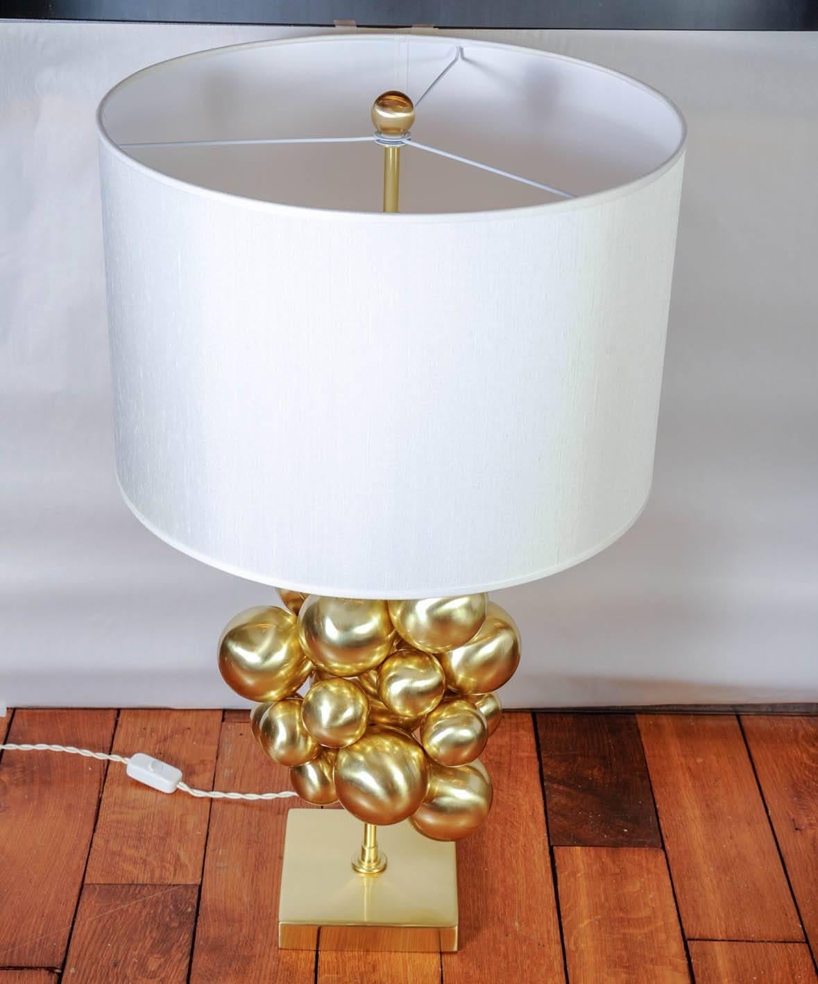 Pair of elegant table lamps made entirely of brass. Square foot with central stem holding a cloud of multiple spheres of different sizes.