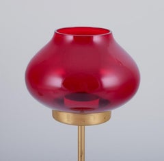 Pair of brass tealight holders in wine-red glass shades. Swedish design.