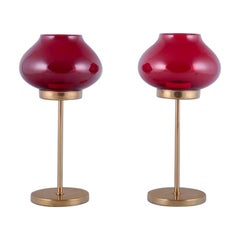 Pareja de portacandelitas de latón con pantallas de cristal rojo vino. Diseño sueco.