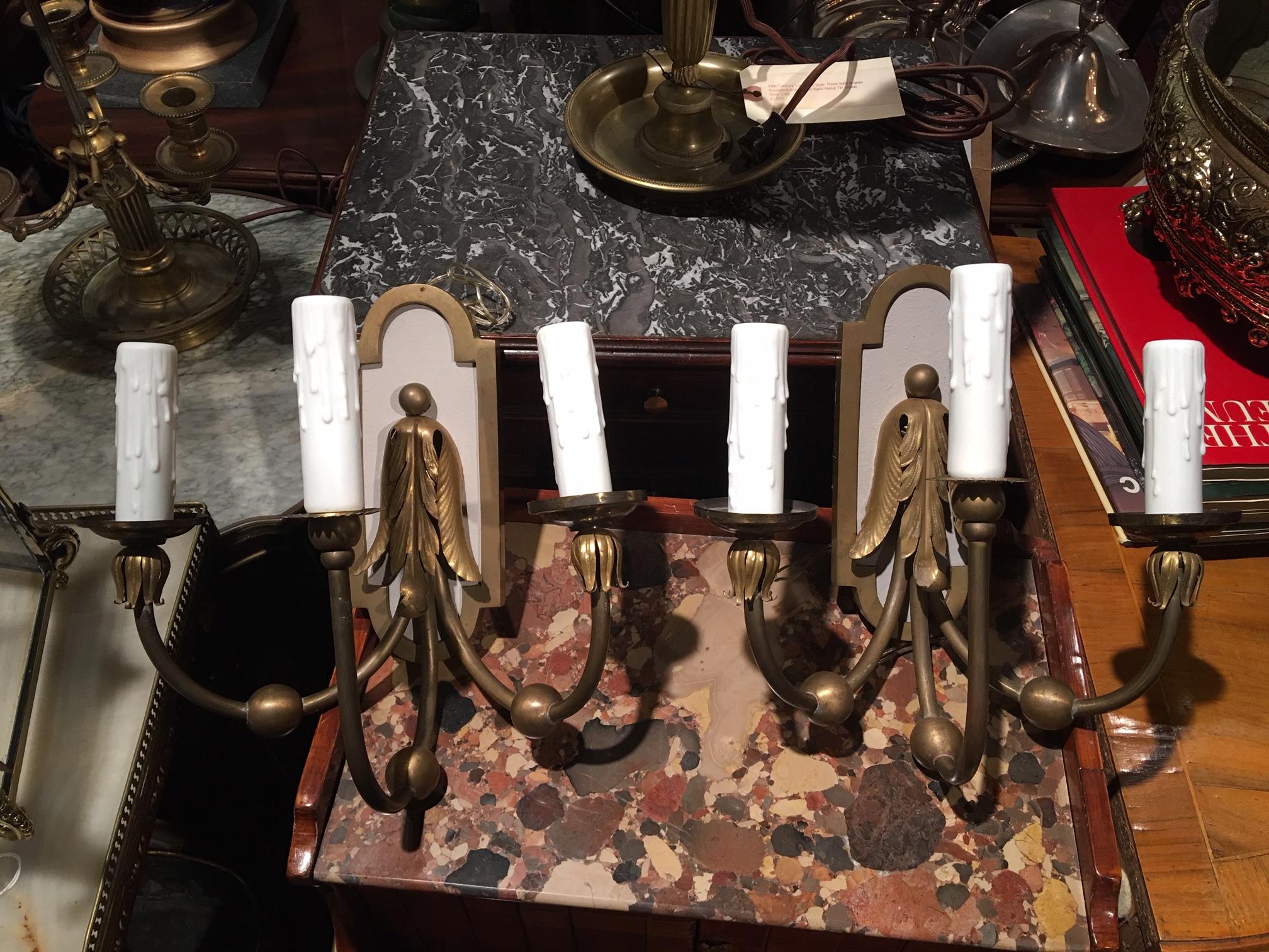 Pair of brass three-light sconces with painted backs, 20th century.