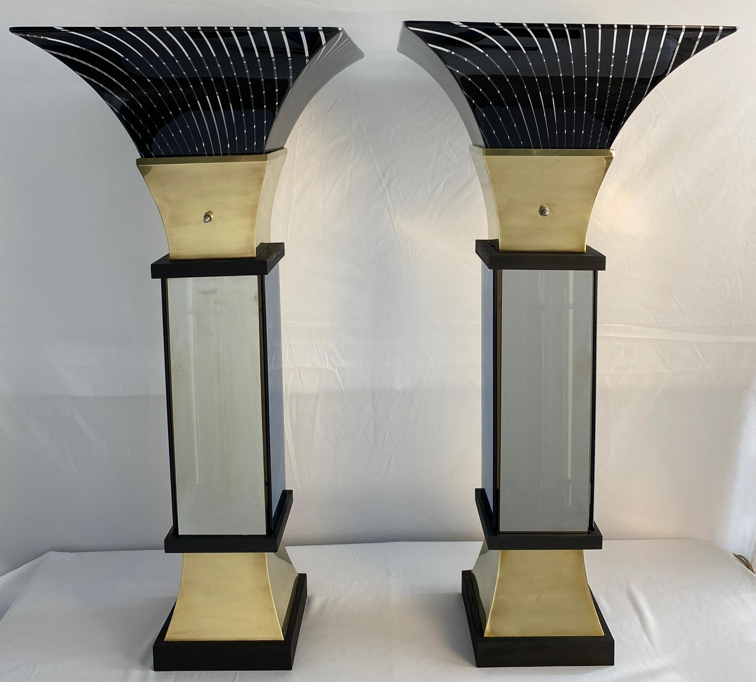 Elevate your space with the captivating glow of this Art Deco-inspired pair of Liteline infinity torchiere lamps (circa 1970s).  Channeling the elegance of Gaetano Scolari's designs, these lamps feature a sleek silhouette with a fluted brass base